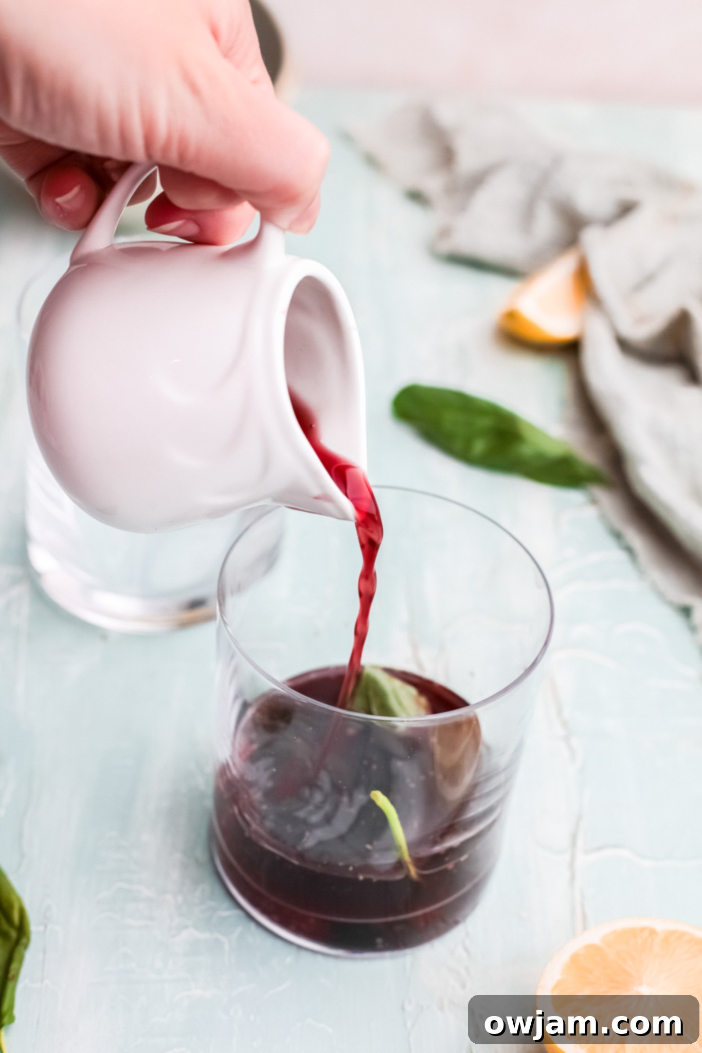 Pouring cherry juice into a glass for Vodka Cherry Limeade.