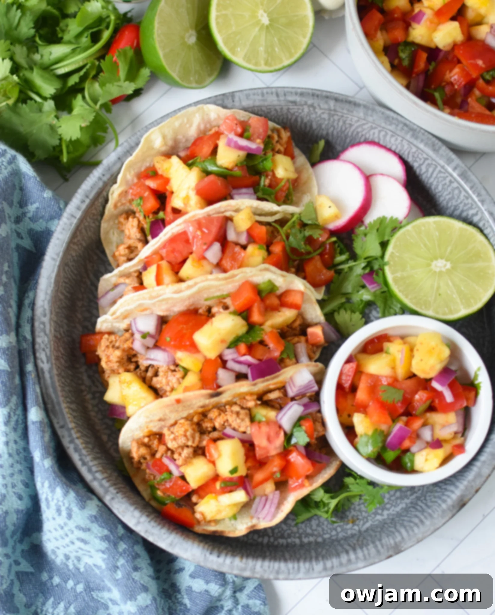 Effortless Ground Pork Tacos 4 Easy Ground Pork Tacos served on a blue platter, garnished with fresh cilantro and lime wedges.