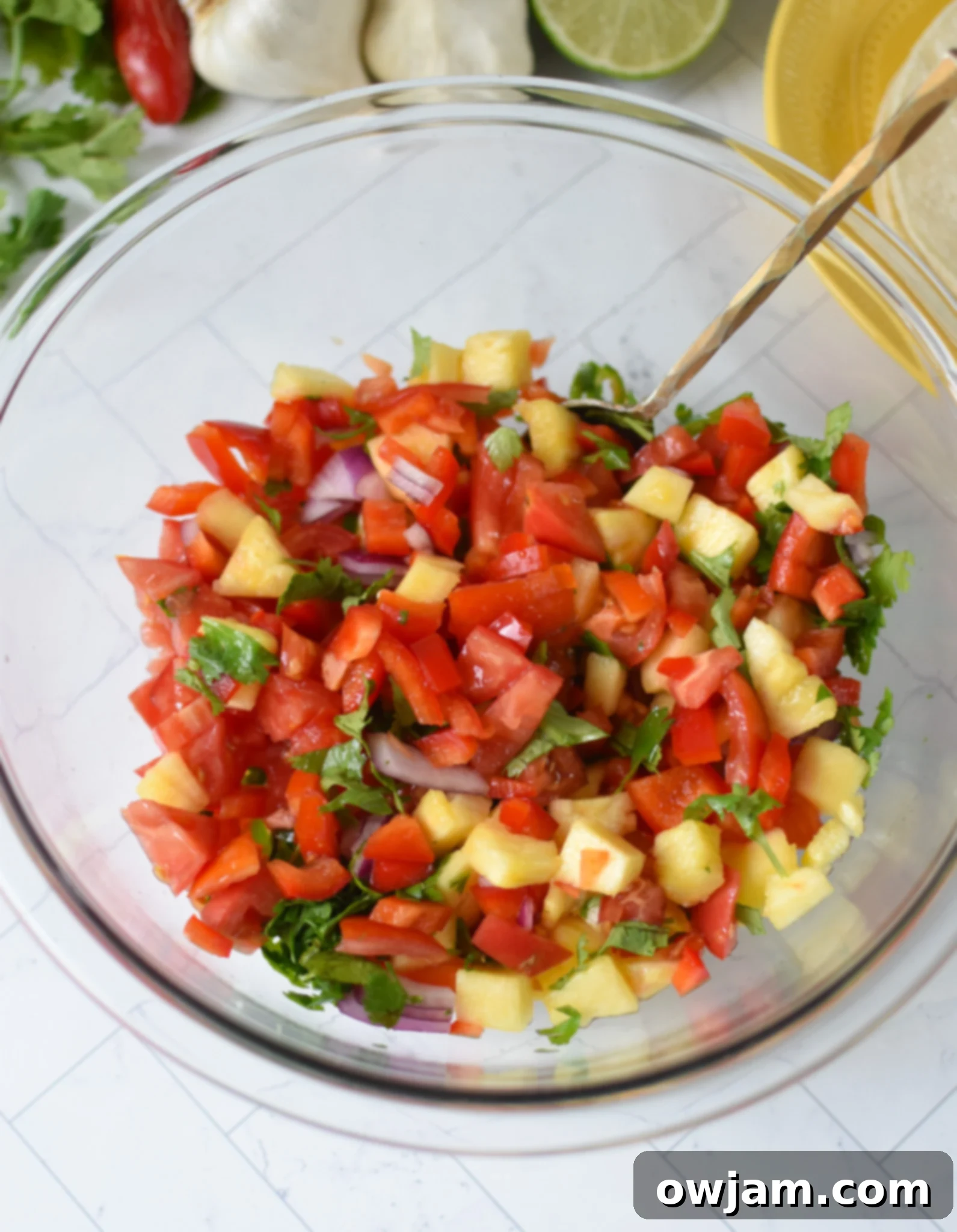 Effortless Ground Pork Tacos 6 Fresh ingredients for pineapple salsa, including diced pineapple, red onion, bell pepper, and cilantro, in a large mixing bowl.