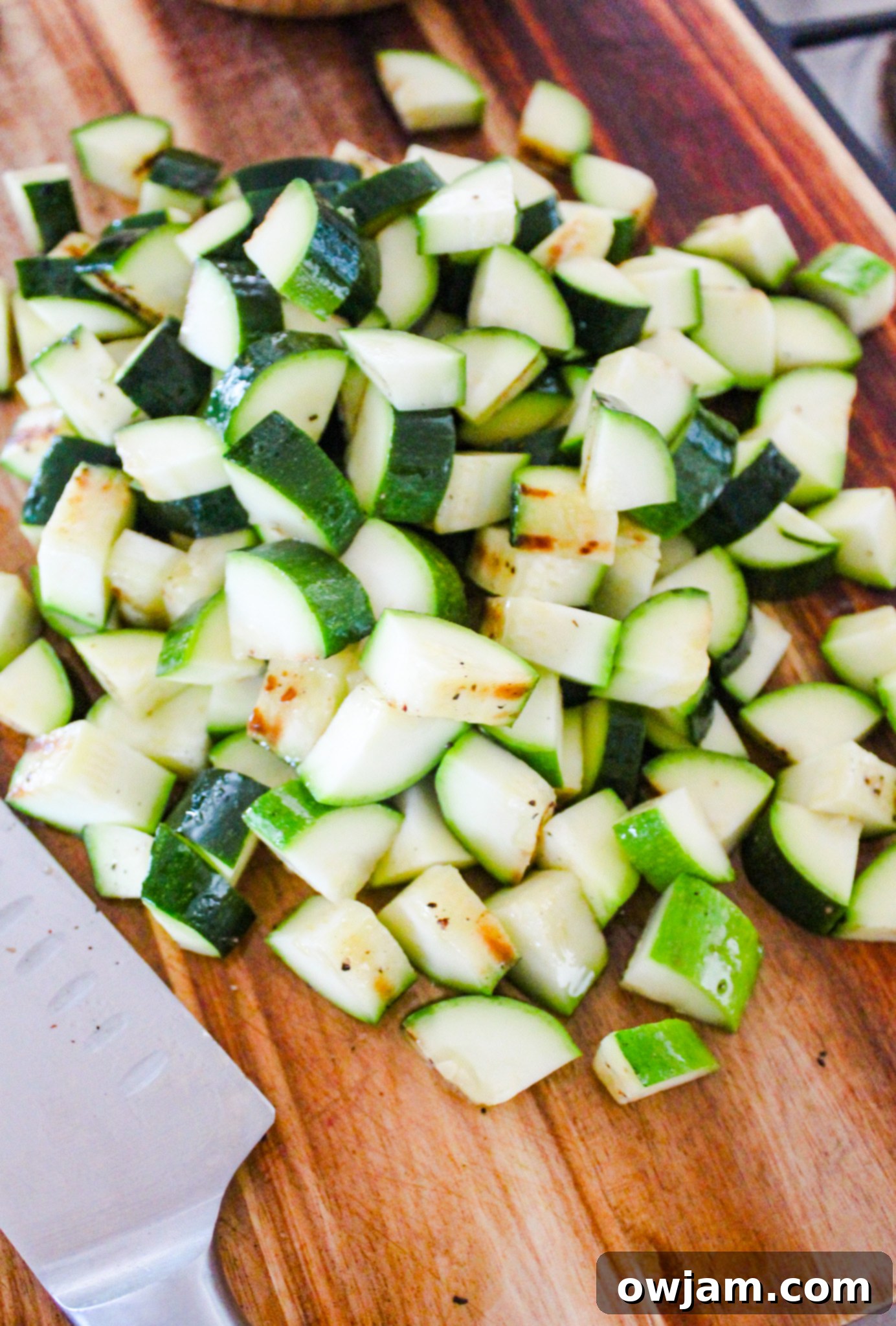 Zesty Zucchini Tacos 6 Grilled zucchini being chopped on a wooden cutting board.