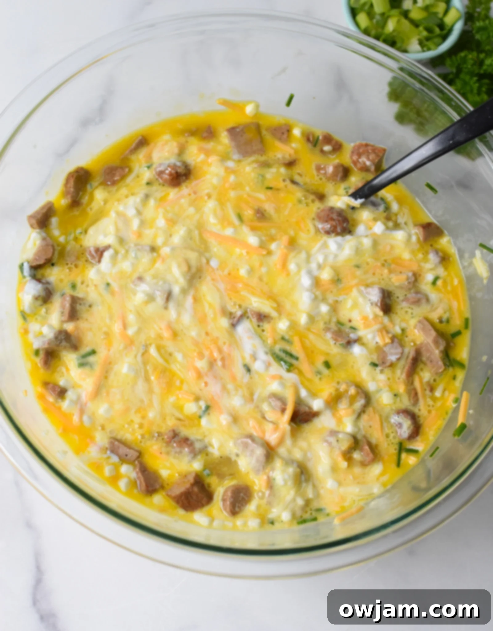 Cottage Cheese Baked Eggs mixture being stirred in a large bowl.