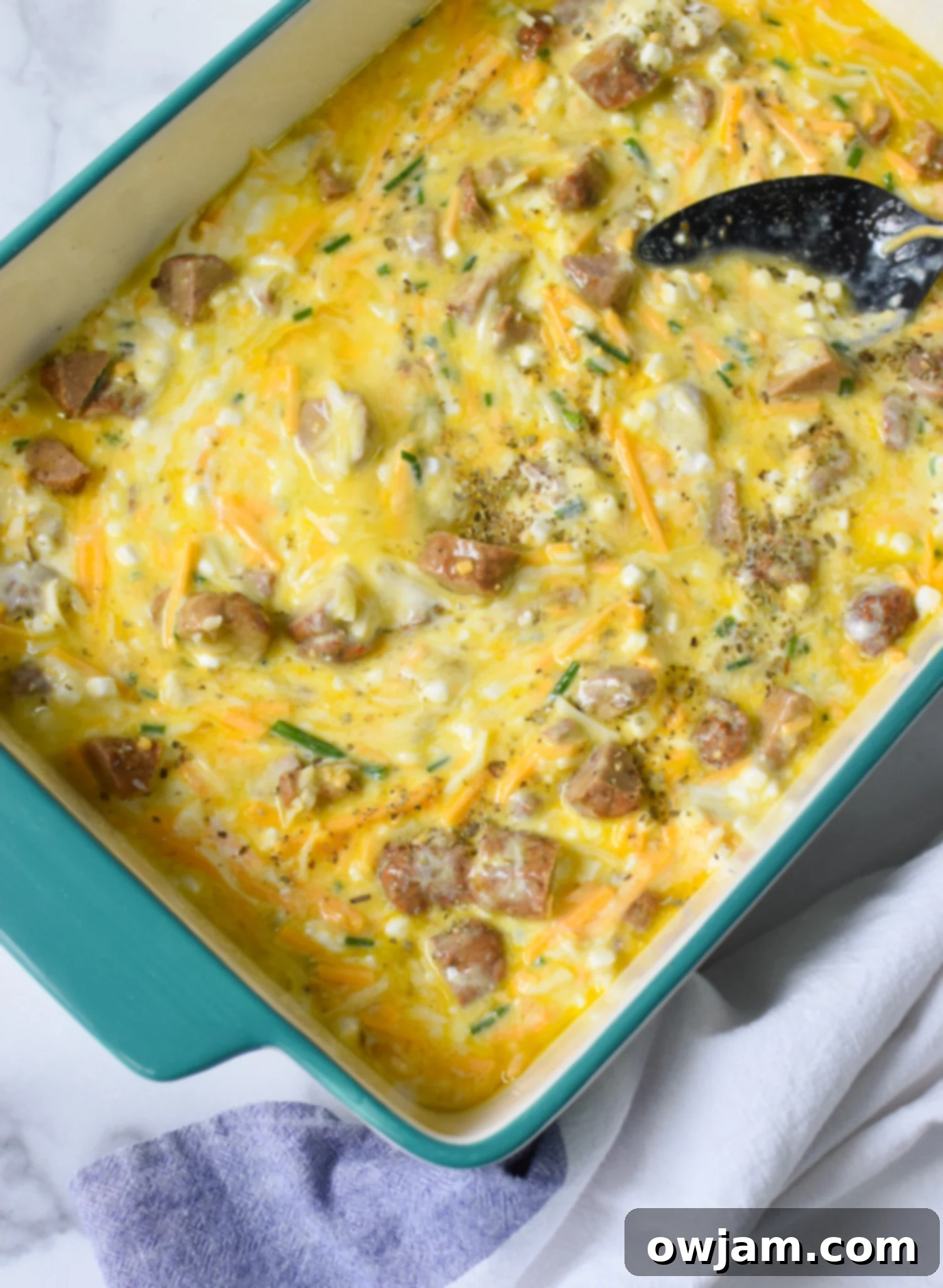 The mixed ingredients for Cottage Cheese Baked Eggs poured into a 9x13 inch casserole dish, ready for baking.