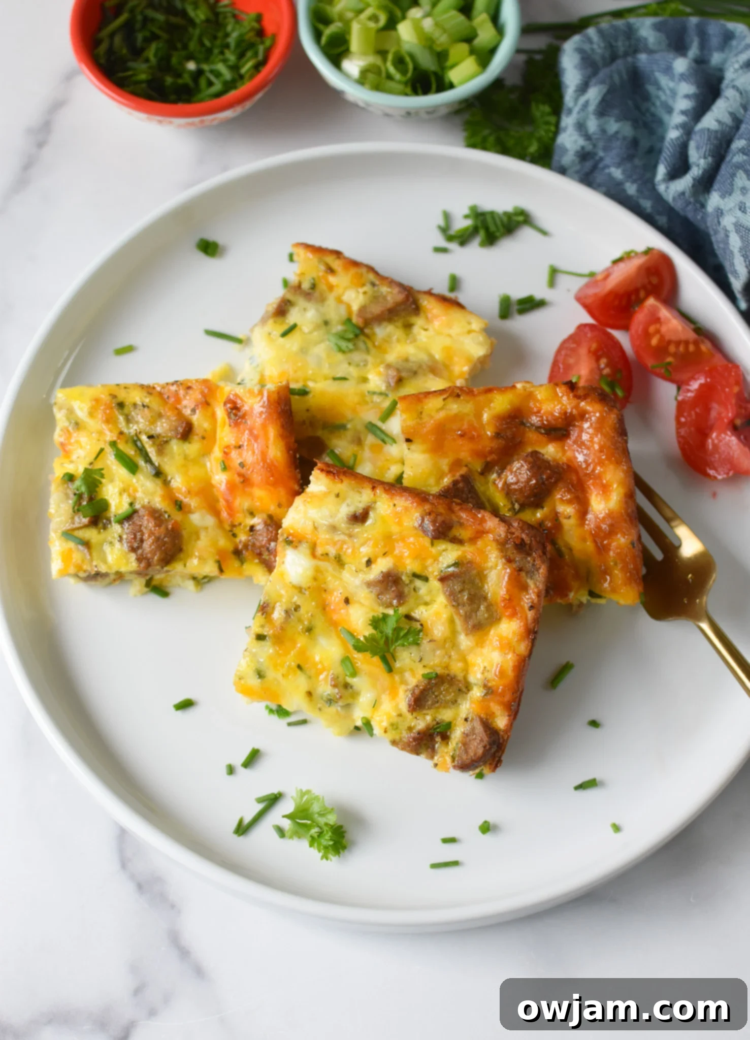 A serving of Cottage Cheese Baked Eggs on a plate, garnished with fresh herbs and a side of cherry tomatoes.