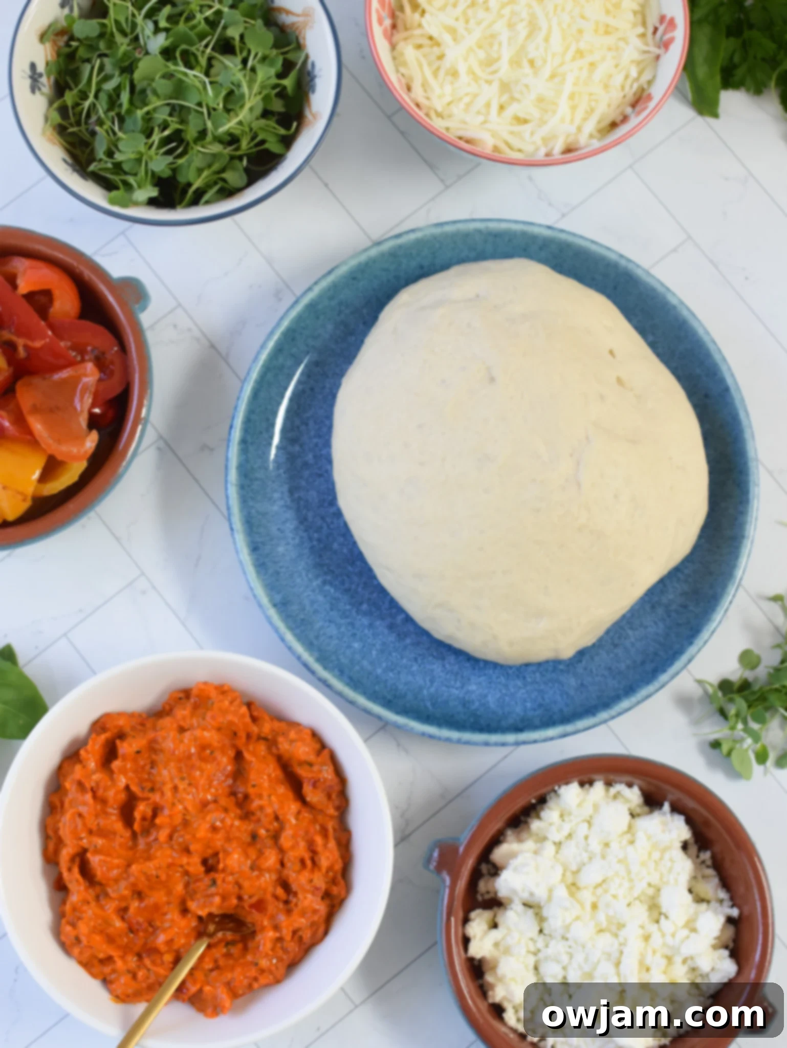 Rustic Cast Iron Mediterranean Pizza 4 Cast Iron Mediterranean Pizza ingredients laid out on a kitchen counter.