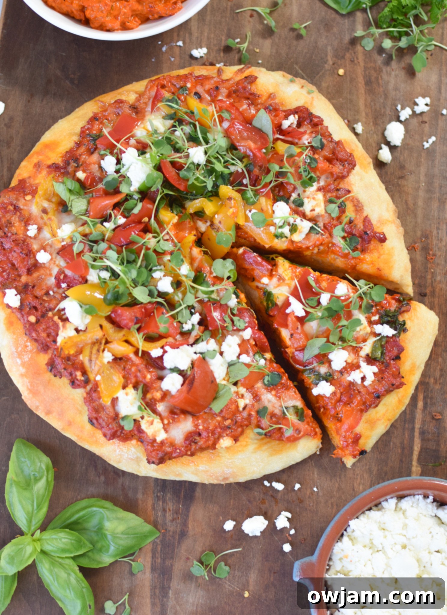 Rustic Cast Iron Mediterranean Pizza 5 A slice of Cast Iron Mediterranean Pizza being served on a white plate, showcasing the crispy crust and toppings.