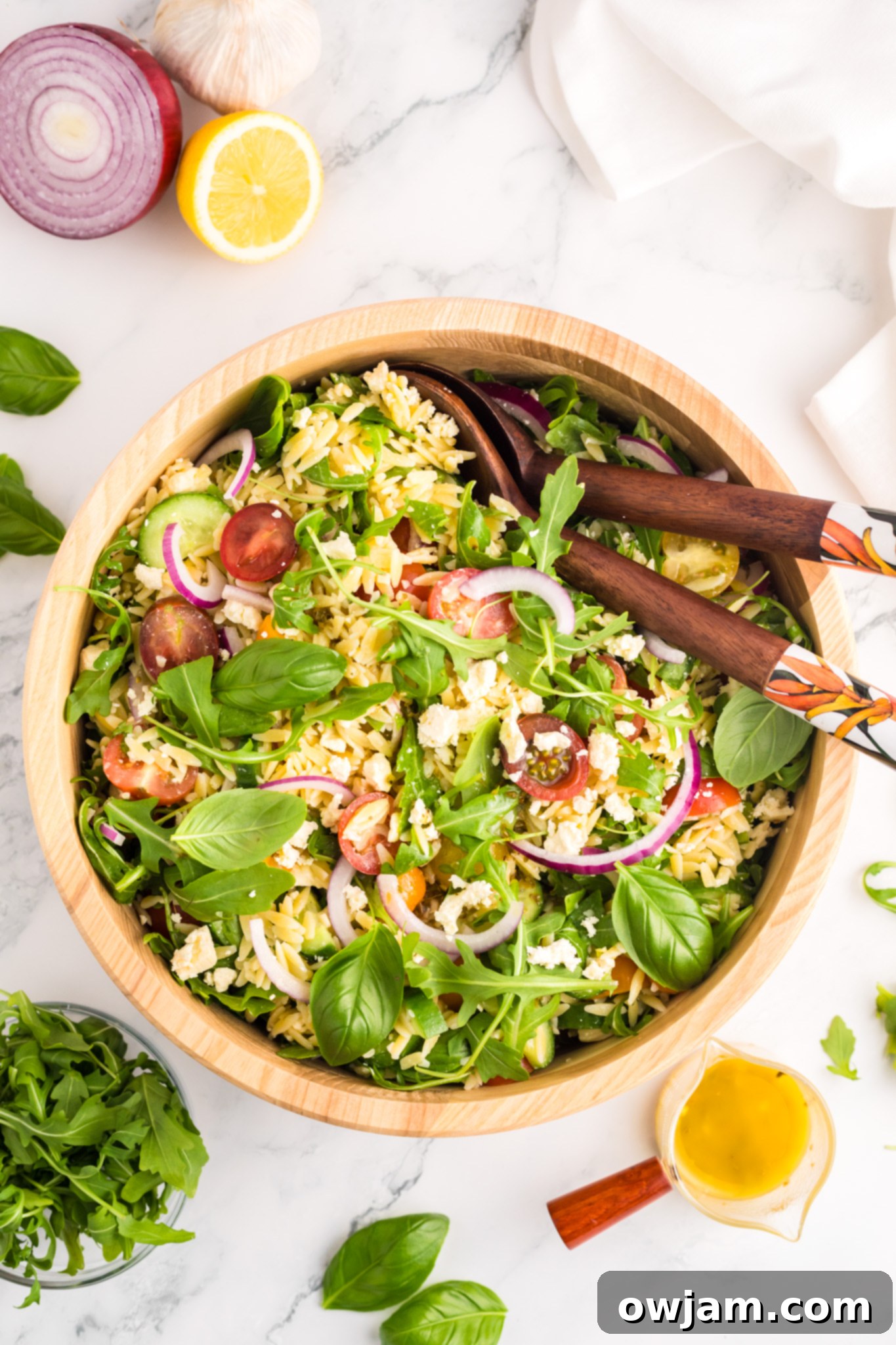 Arugula Orzo Salad served in a large wooden bowl, showcasing the fresh, colorful ingredients.