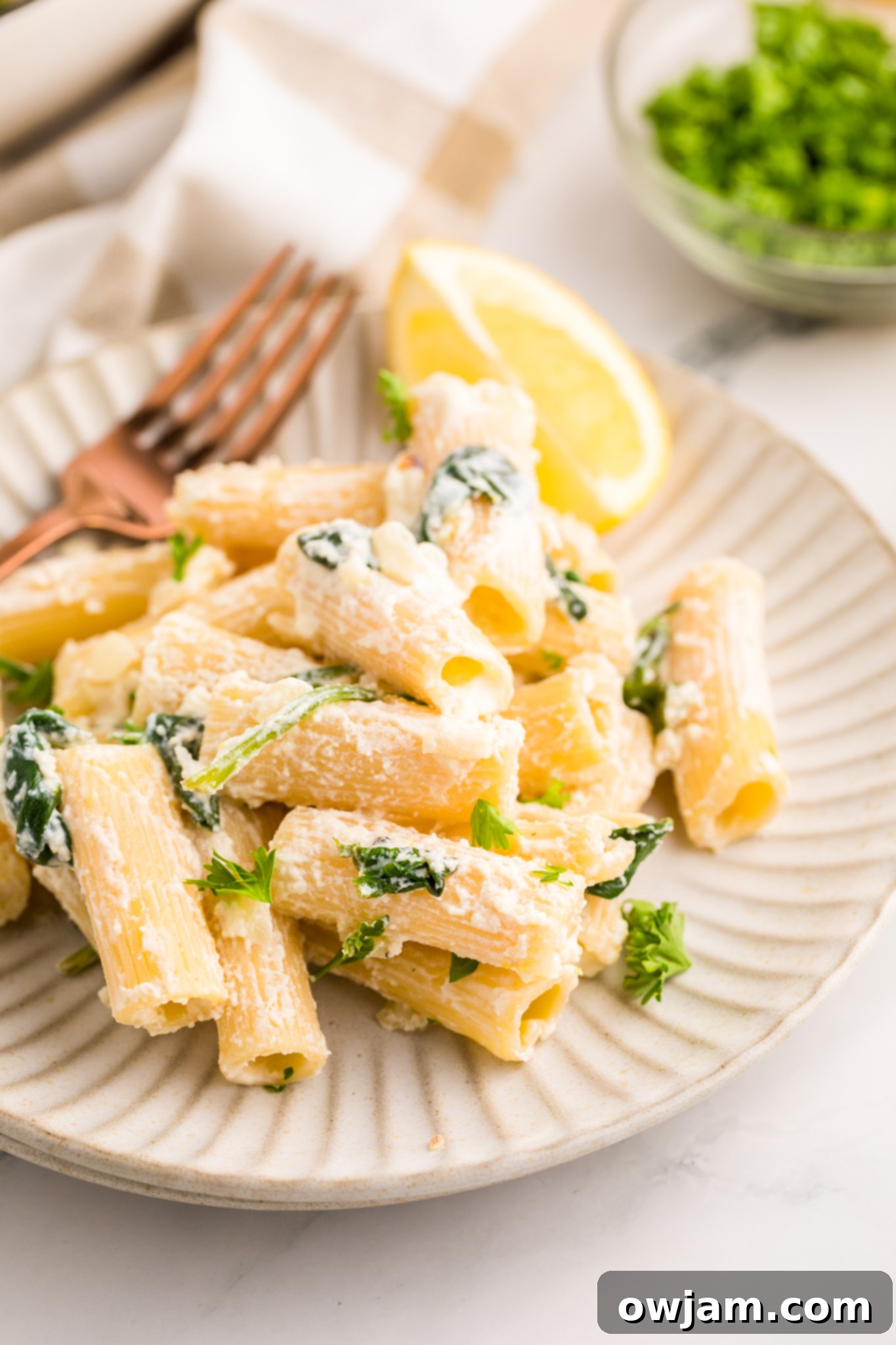 Zesty Lemon Ricotta Pasta 3 Close-up of Lemon Ricotta Pasta with a fork twirling pasta, showcasing the creamy sauce and fresh spinach.