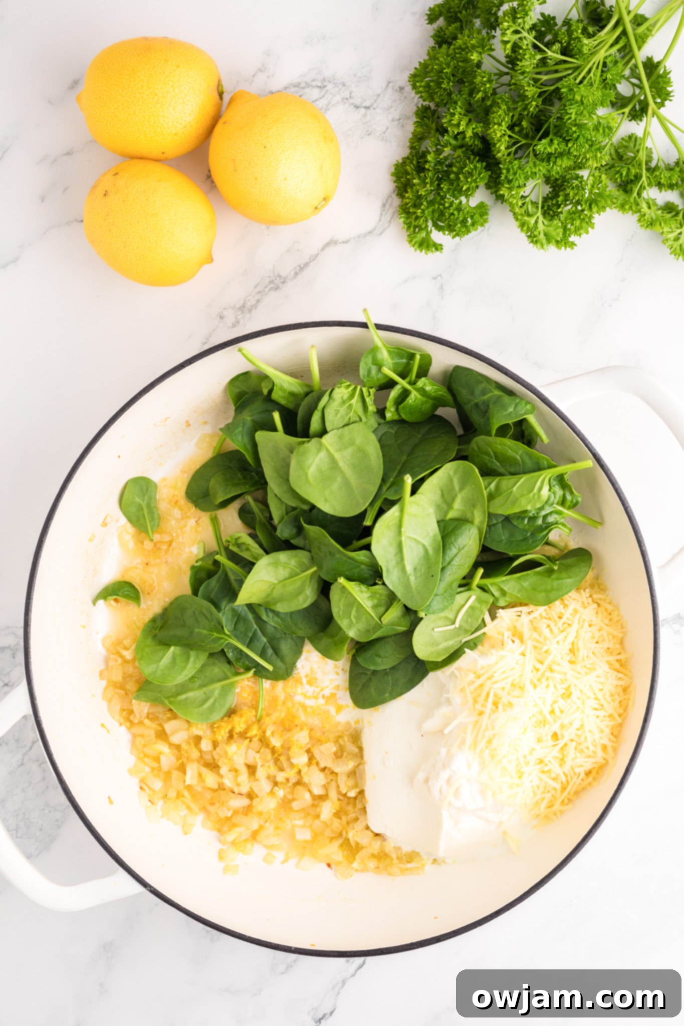 Zesty Lemon Ricotta Pasta 7 Ricotta, heavy cream, Parmesan, lemon juice, zest, spinach, and pasta water simmering together in a skillet to form a creamy sauce.