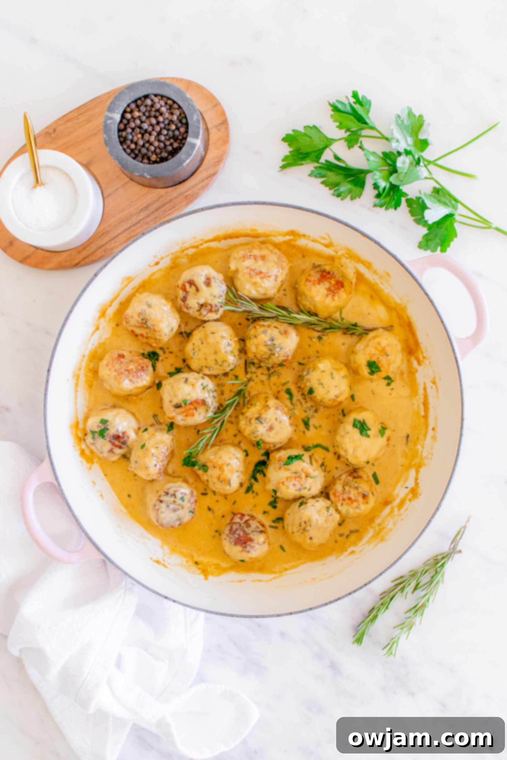 Maple Dijon Turkey Meatballs 11 Maple Dijon Turkey Meatballs garnished with fresh rosemary and ready to serve in a Dutch oven.
