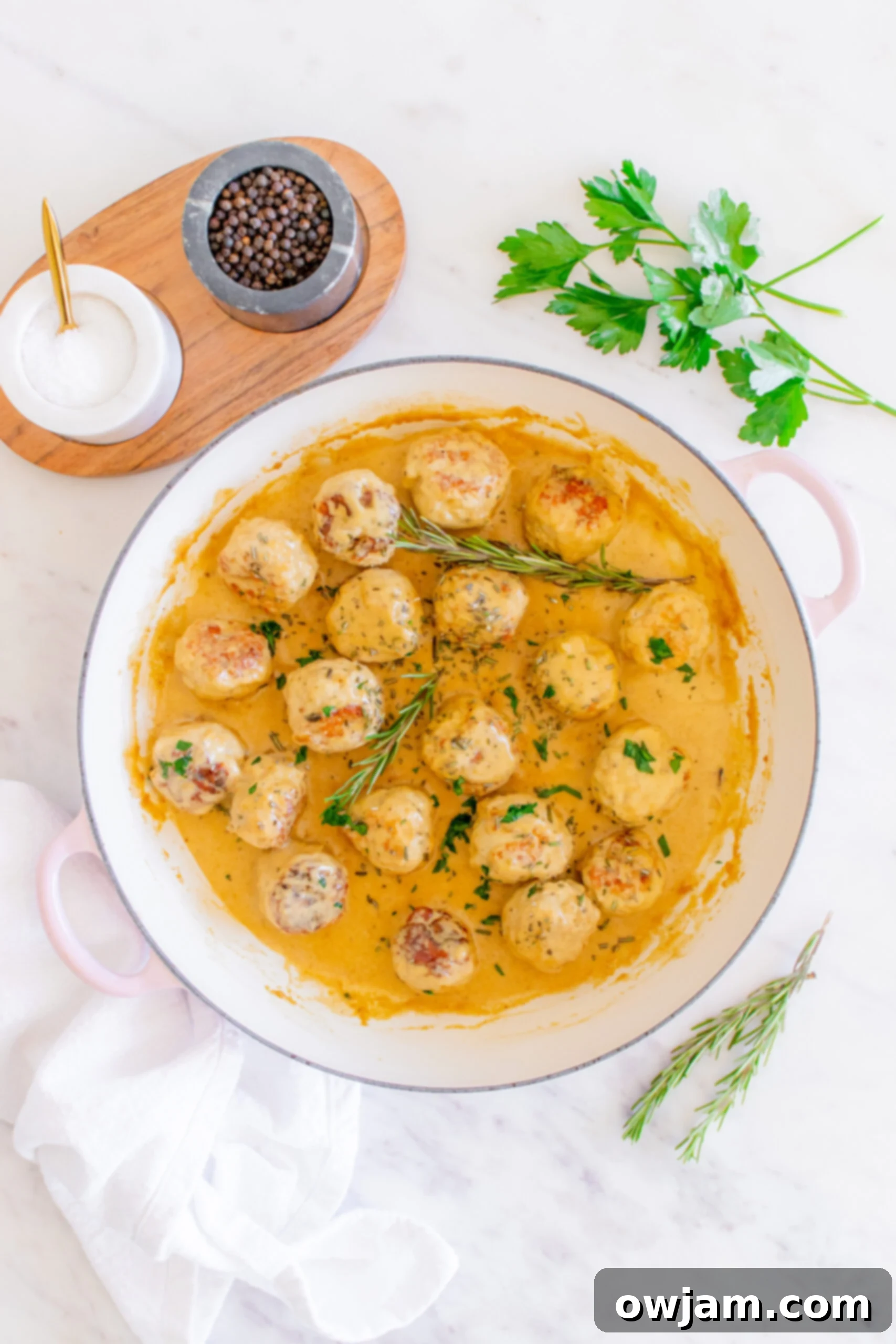 Sweet & Savory Maple Dijon Turkey Meatballs 11 Maple Dijon Turkey Meatballs in a Dutch oven, garnished with fresh rosemary and ready to serve.