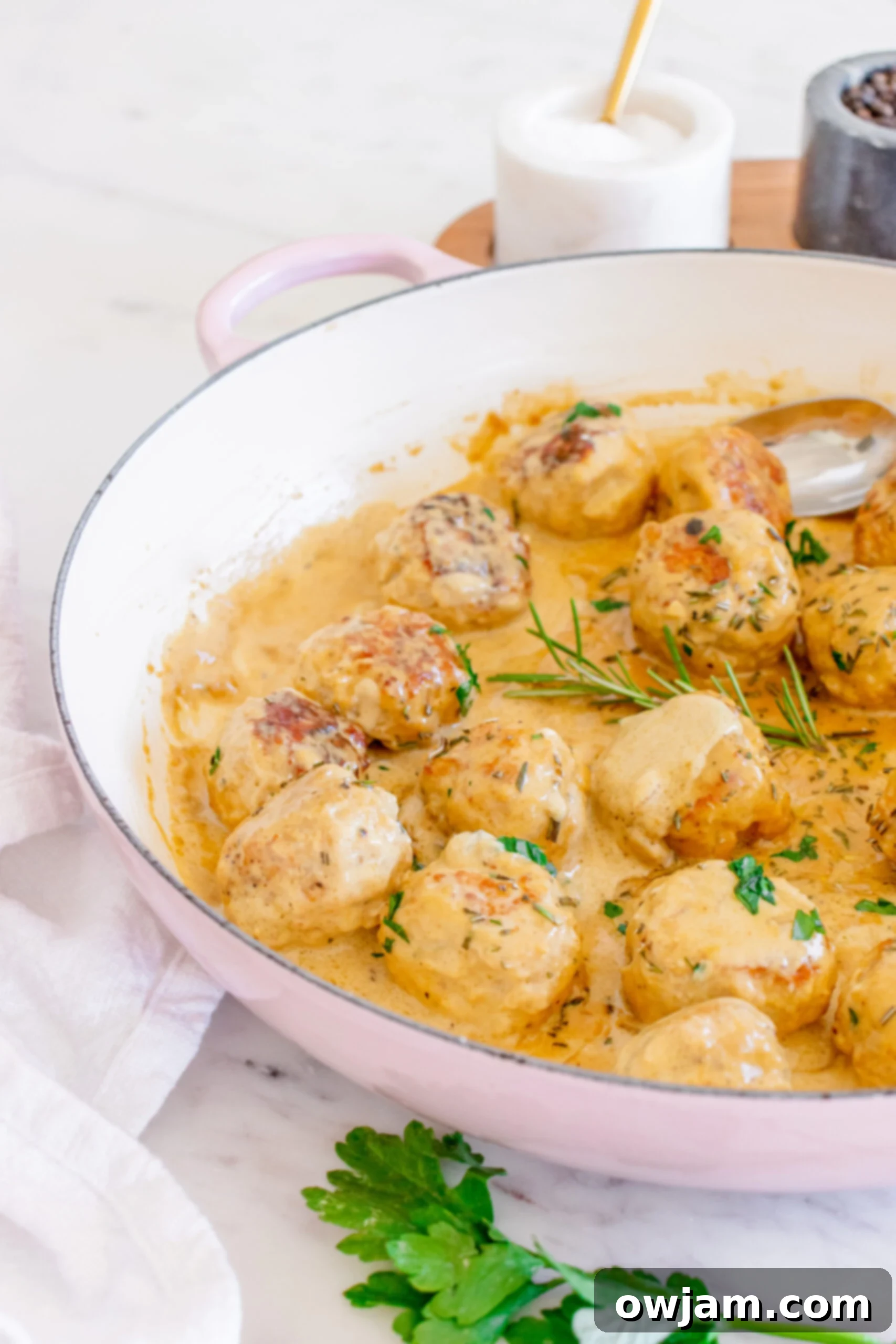 Sweet & Savory Maple Dijon Turkey Meatballs 12 A serving of Maple Dijon Turkey Meatballs, with a spoon scooping up a meatball and sauce.