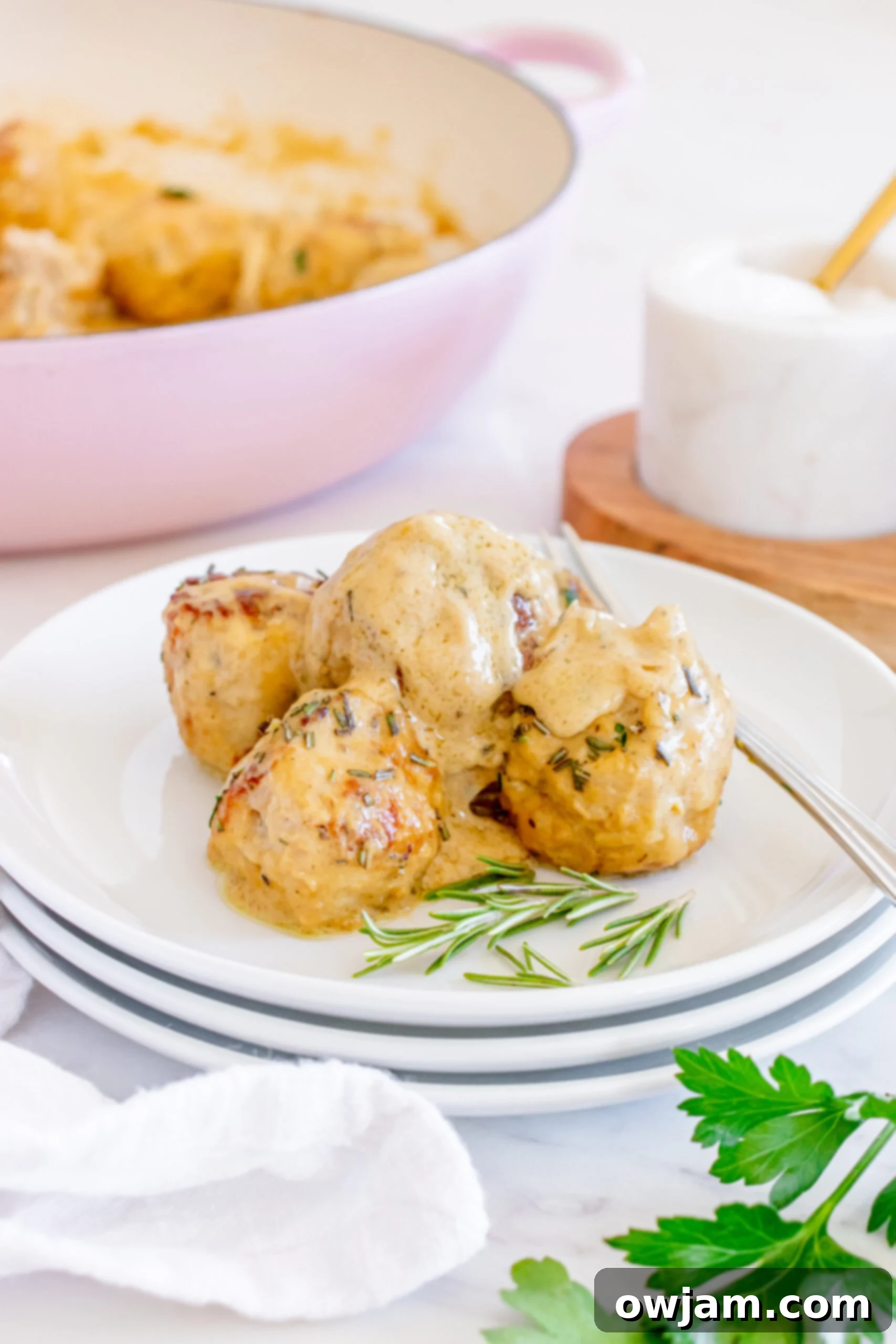 Sweet & Savory Maple Dijon Turkey Meatballs 3 A single Maple Dijon Turkey Meatball being lifted with a fork, showcasing its texture and the creamy sauce.