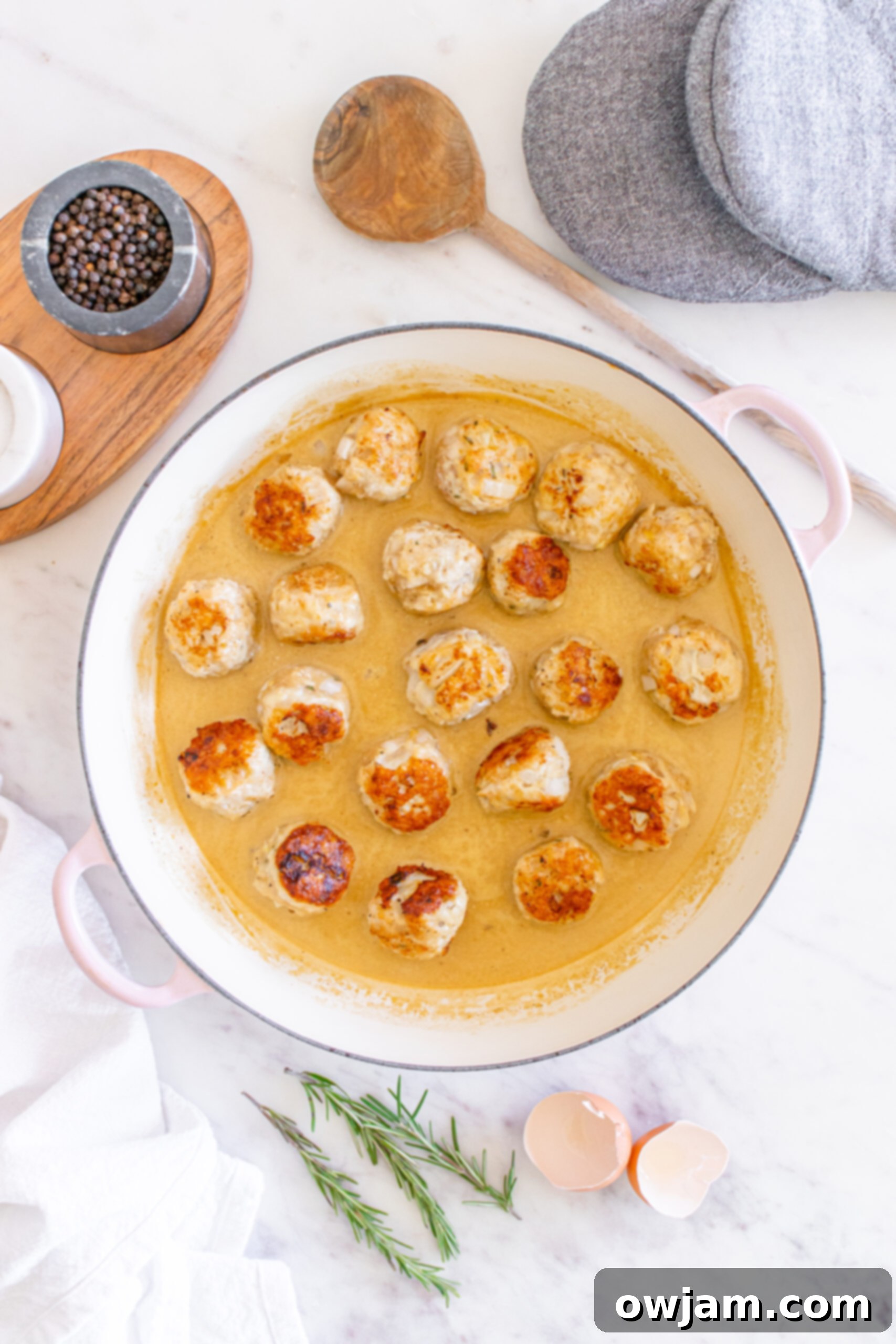 Maple Dijon Turkey Meatballs 10 Cooked Maple Dijon Turkey Meatballs submerged in the creamy sauce in a Dutch oven.