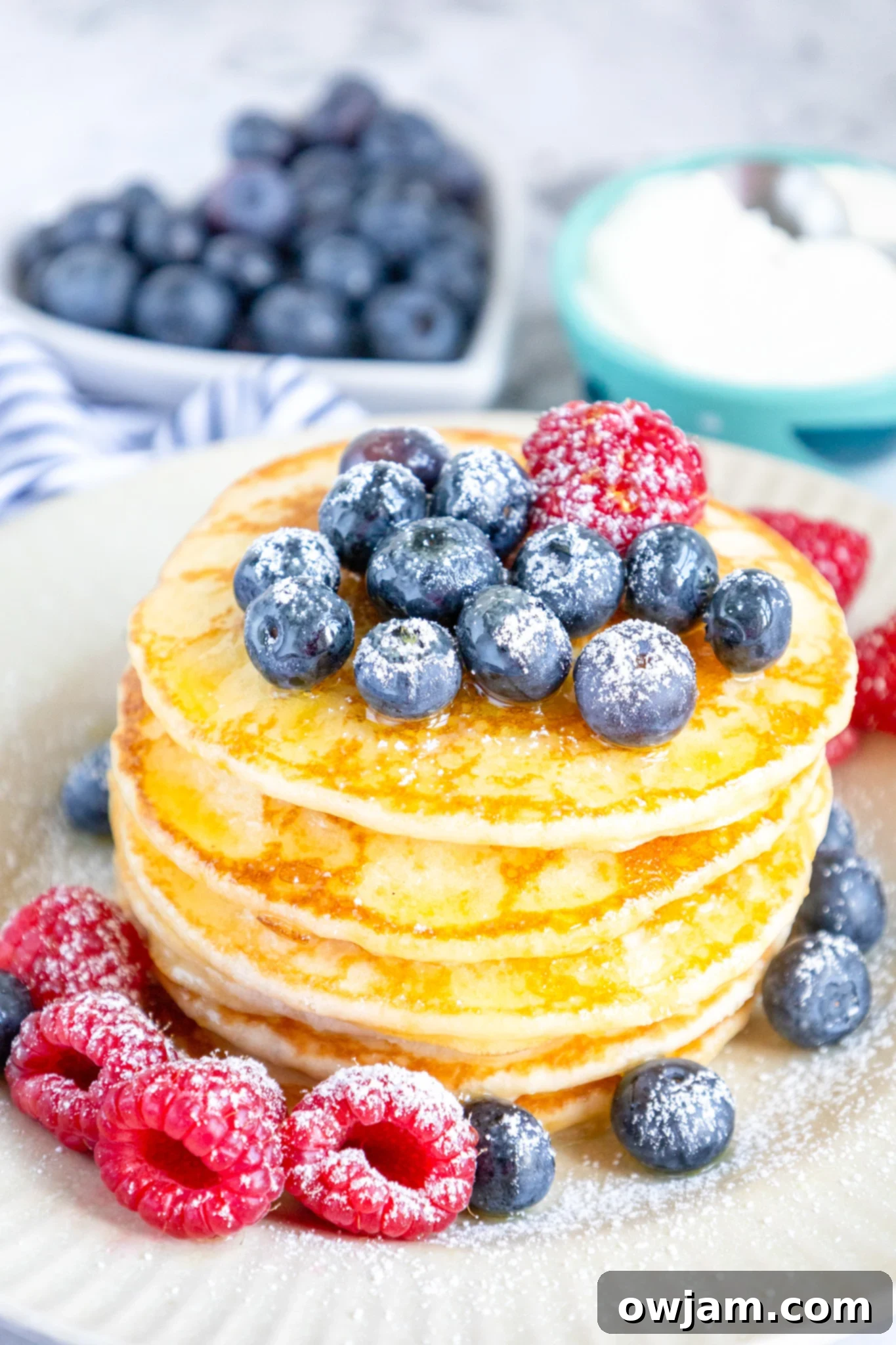 Cloud-Soft Buttermilk Pancakes 2 Stack of fluffy homemade buttermilk pancakes topped with fresh blueberries.