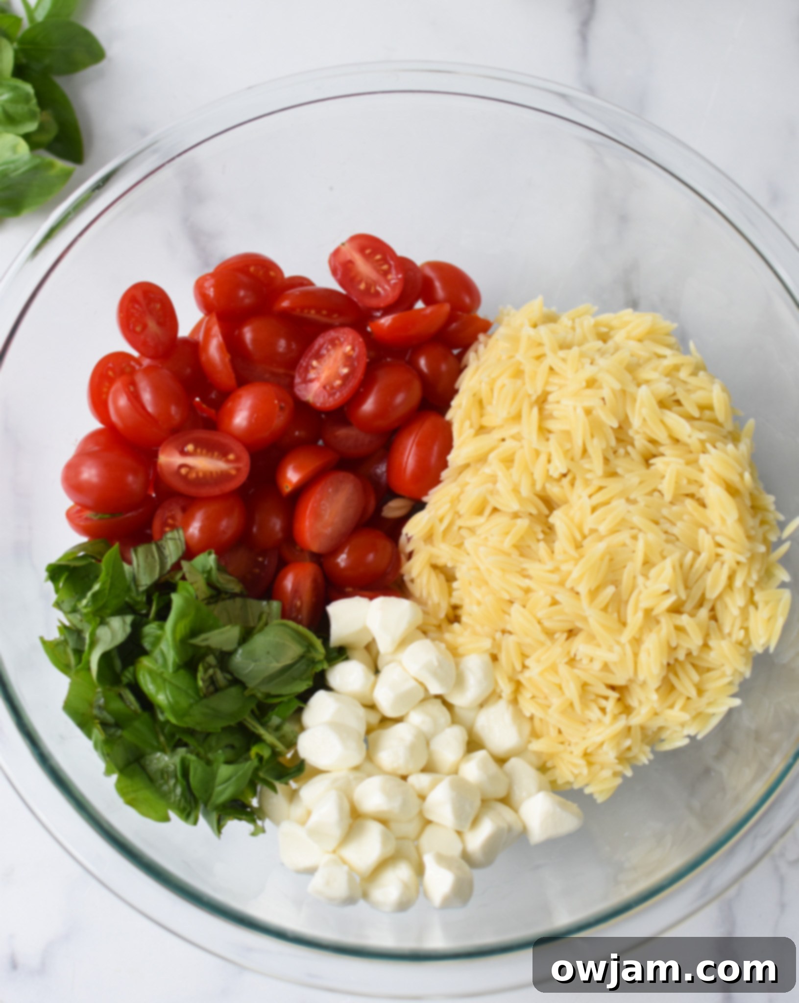 Caprese Orzo Pasta Salad ingredients in a bowl. 