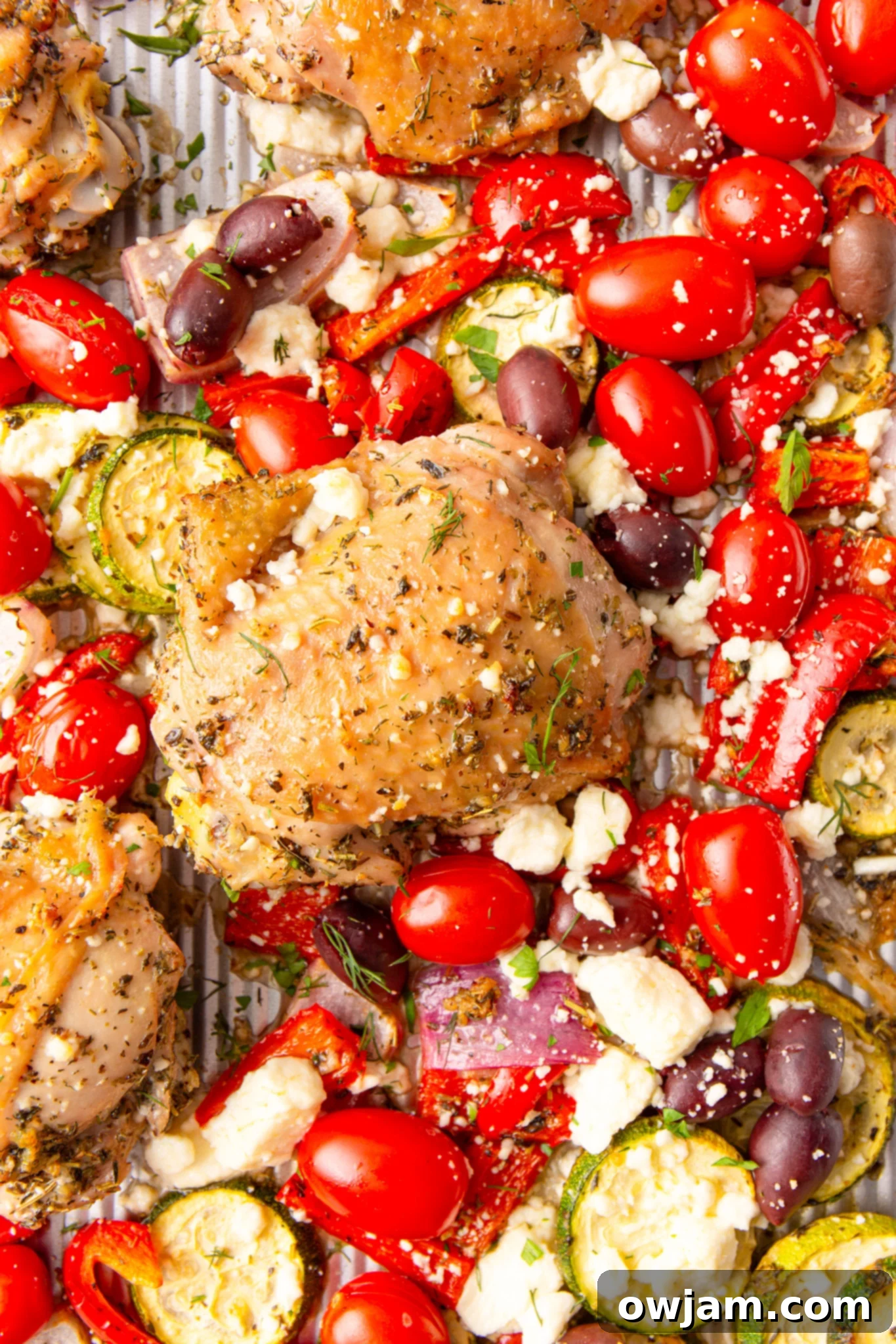 Mediterranean Sheet Pan Chicken 9 Mediterranean Sheet Pan Chicken with fresh herbs on a baking sheet, freshly out of the oven.