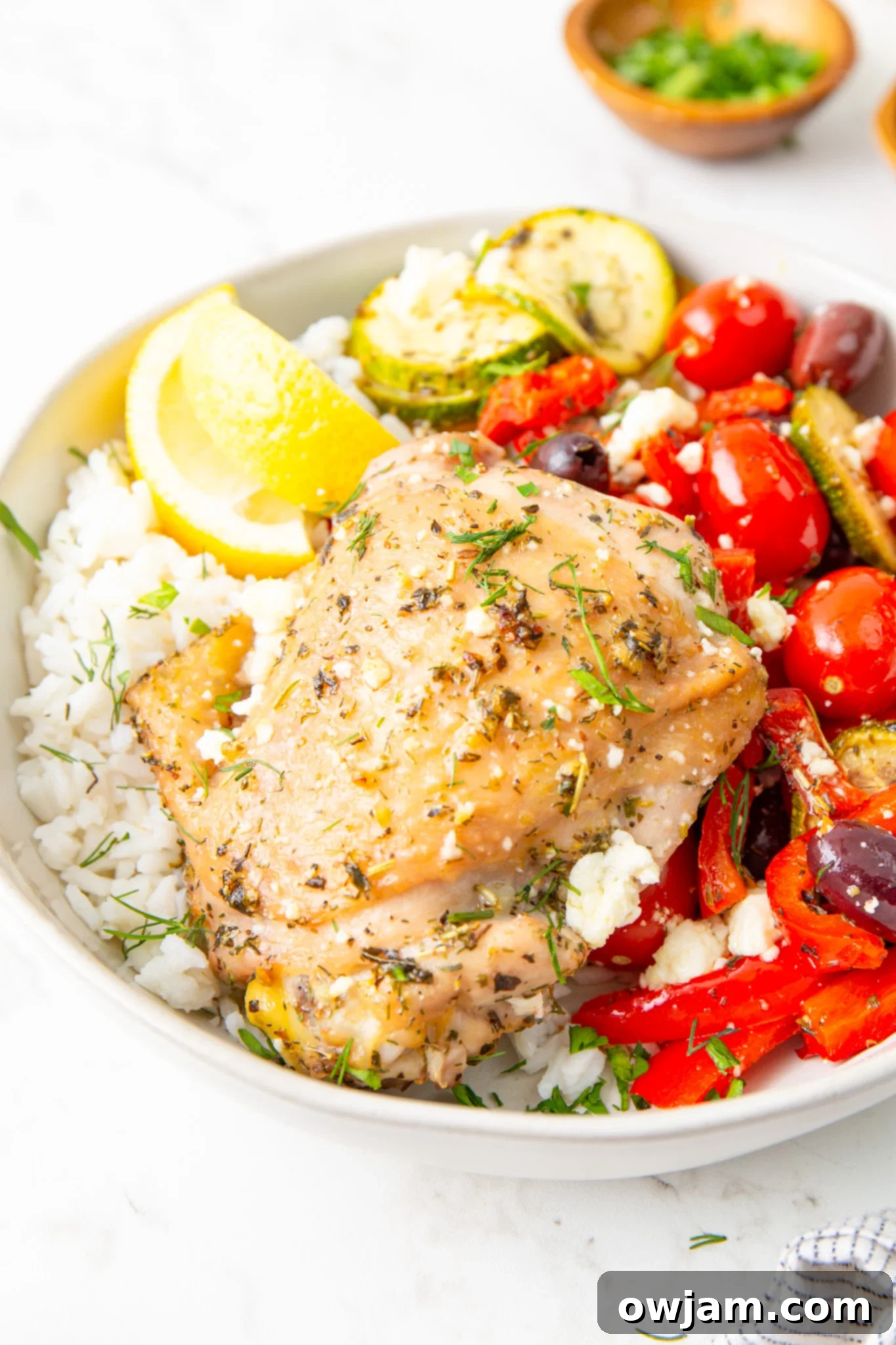 Mediterranean Sheet Pan Chicken 10 Mediterranean Sheet Pan Chicken served in a rustic bowl, garnished with fresh herbs.
