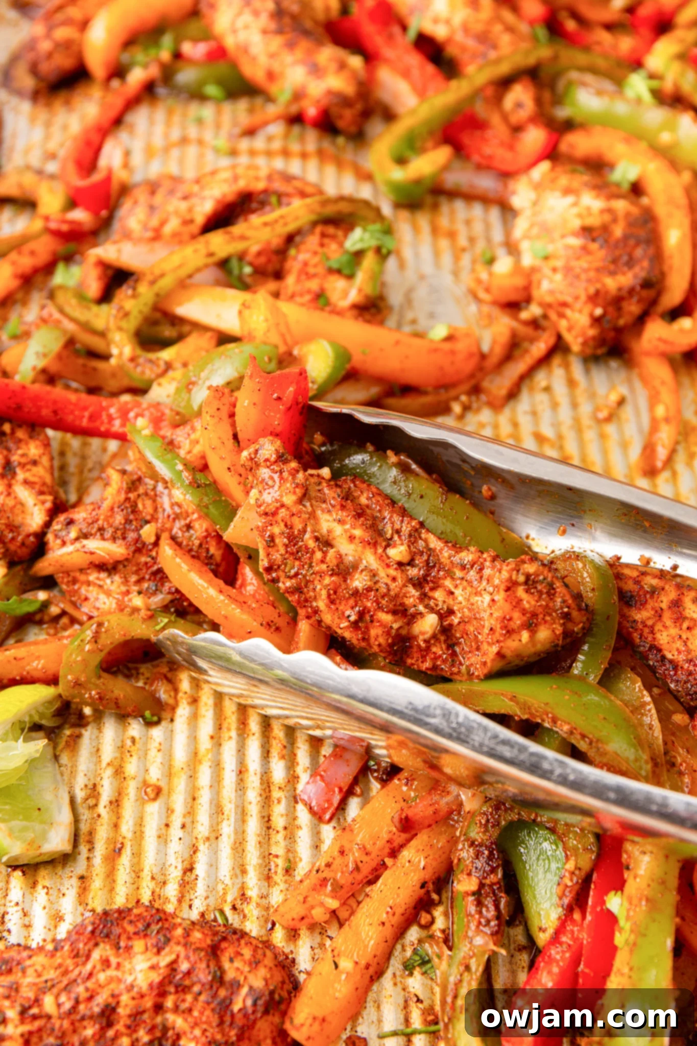One-Pan Chicken Fajita Feast 7 Sheet Pan Chicken Fajitas in tongs