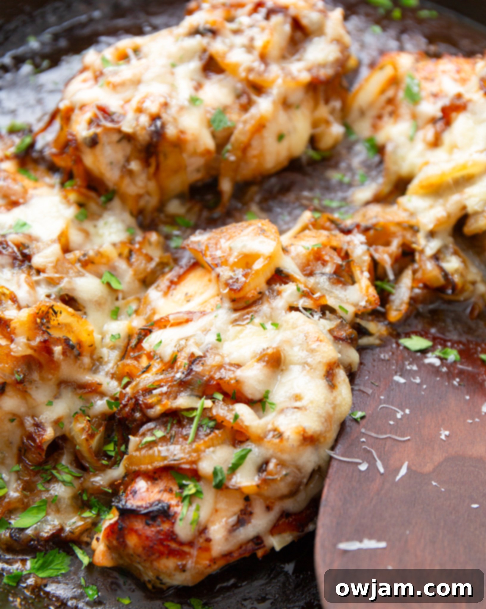 Irresistible French Onion Chicken 2 French Onion Chicken simmering in a skillet, topped with melted cheese.
