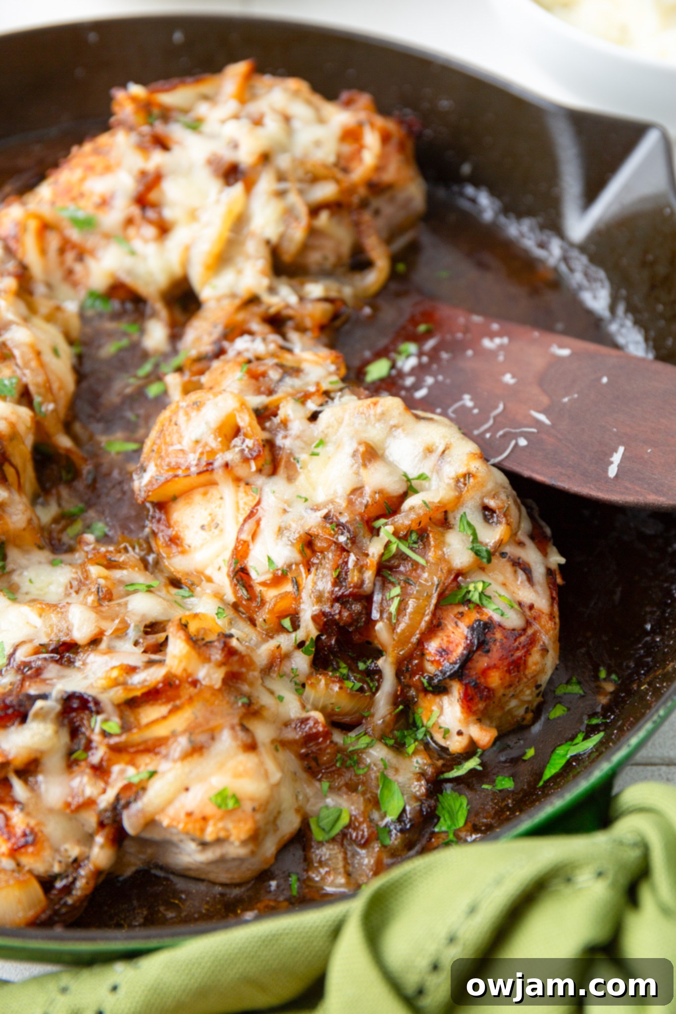 Irresistible French Onion Chicken 12 French Onion Chicken baking in a skillet with melted Gruyère cheese.