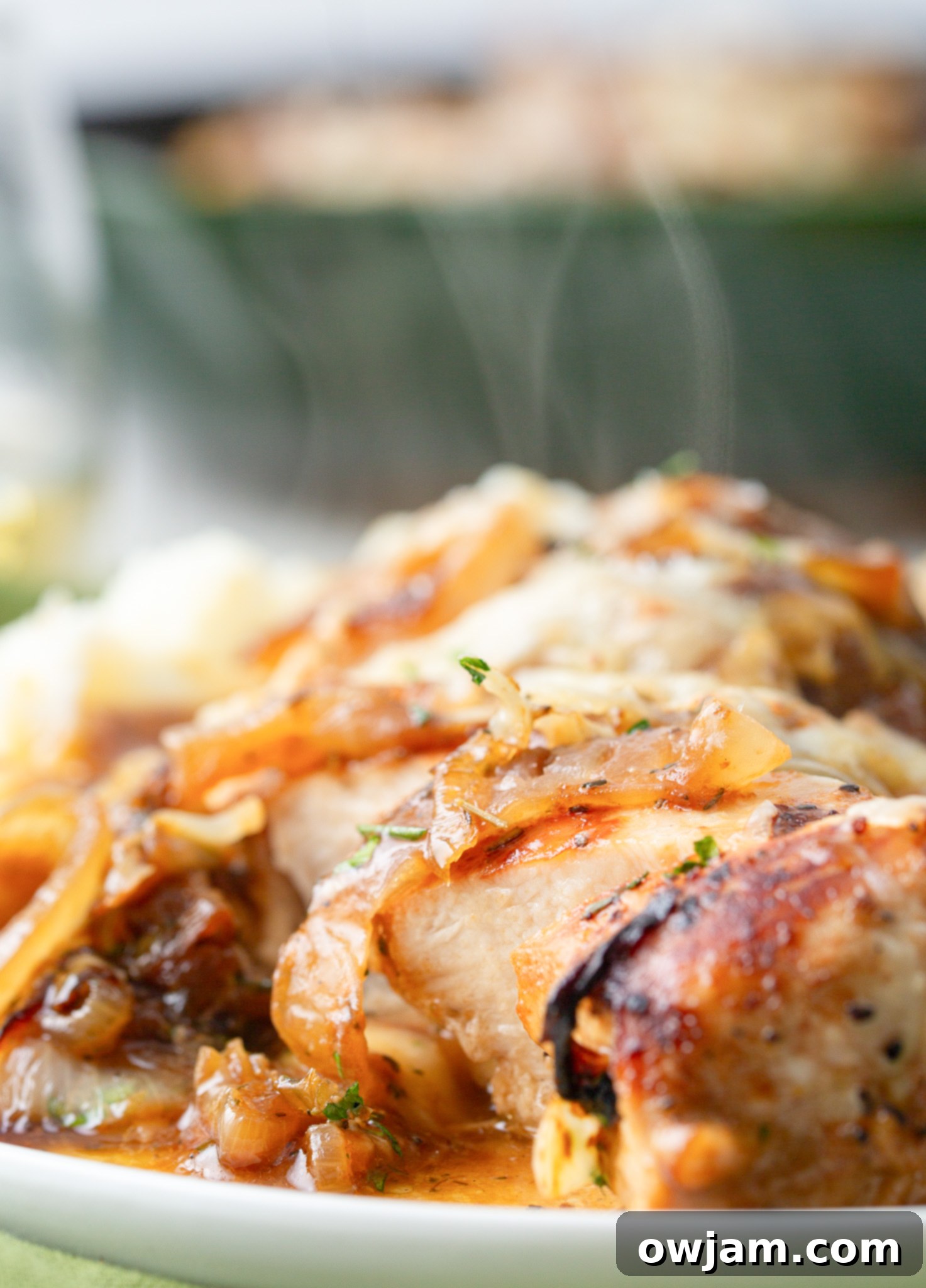 Irresistible French Onion Chicken 5 Close-up of French Onion Chicken with melted cheese and fresh herbs.