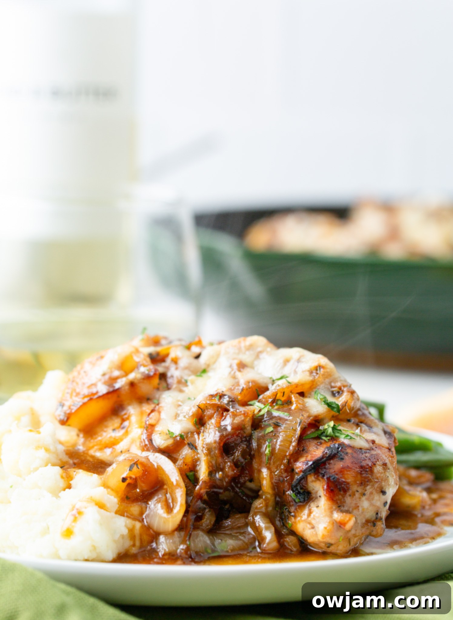 Irresistible French Onion Chicken 10 French Onion Chicken in a skillet with a bottle of white wine in the background.