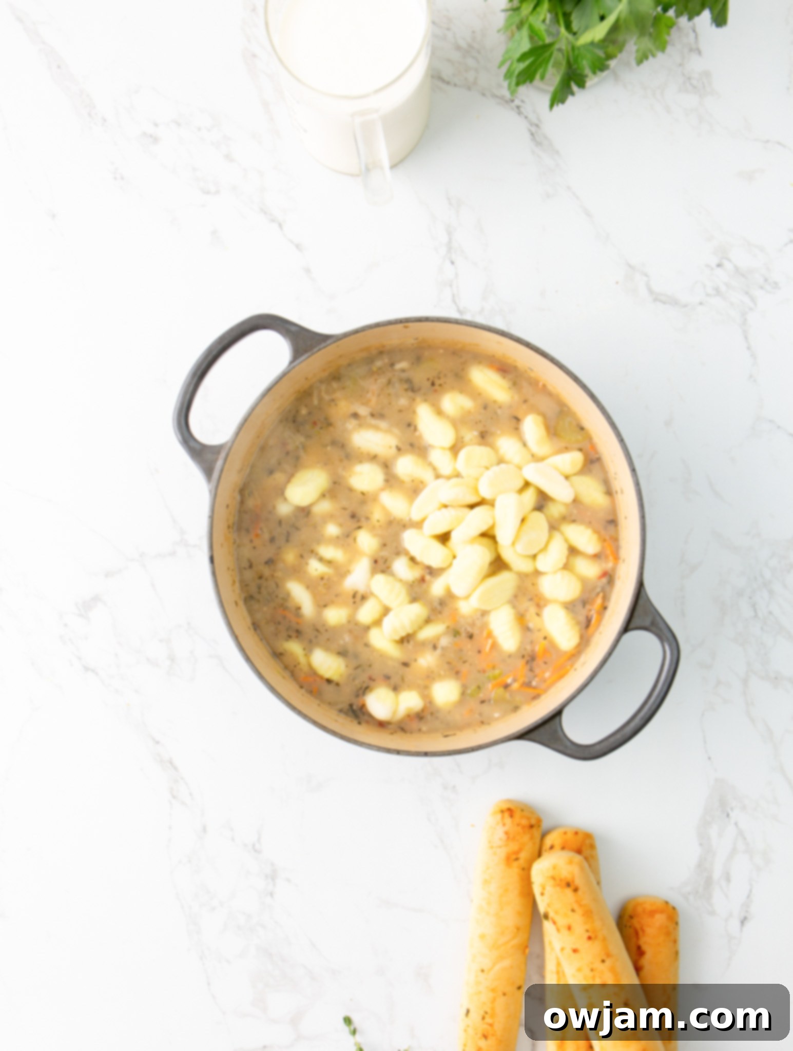 Make Olive Garden Chicken Gnocchi Soup at Home 9 Copycat Olive Garden Chicken Gnocchi Soup gnocchi being added to a pot.