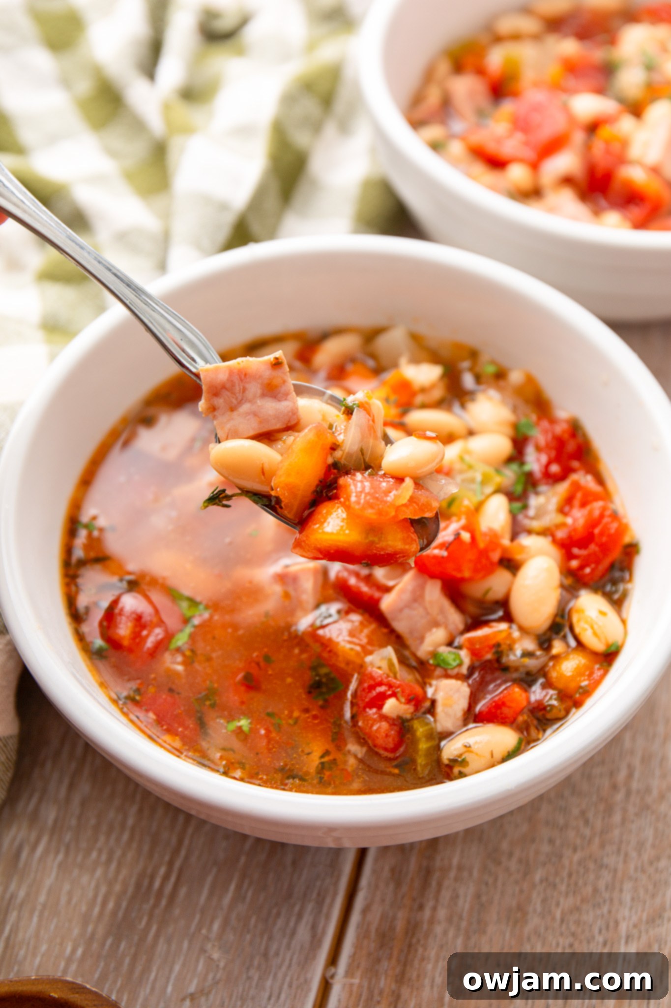 Navy Bean Soup Recipe in a white bowl with a slice of bread