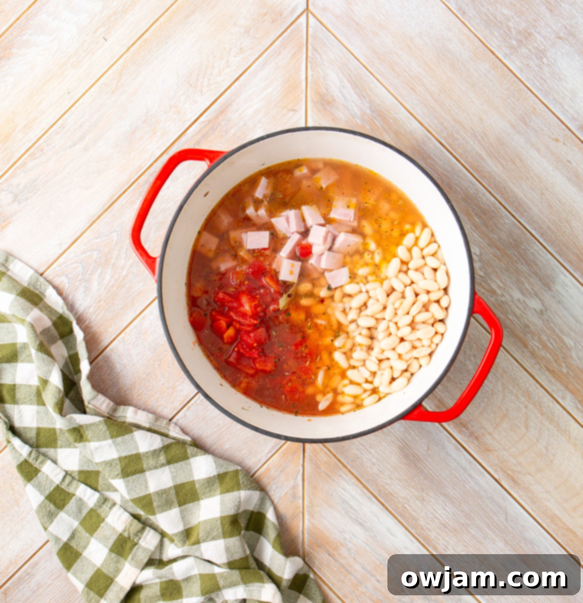 Navy Bean Soup Recipe with tomatoes and ham added to the pot with other ingredients