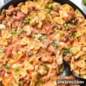 Creamy Chicken and Chorizo Pasta Recipe in a skillet with a spoon