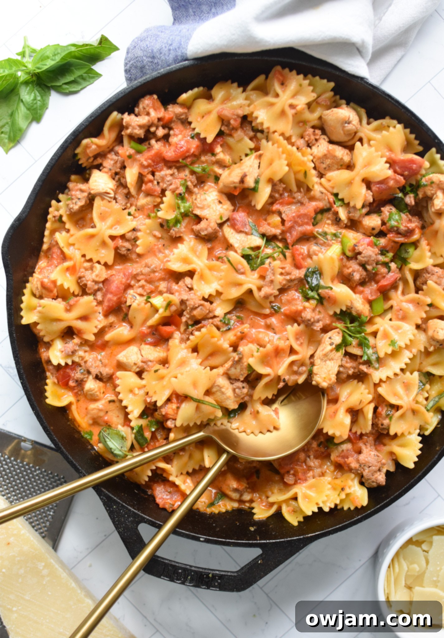 Creamy Chicken and Chorizo Pasta Recipe with gold spoons.