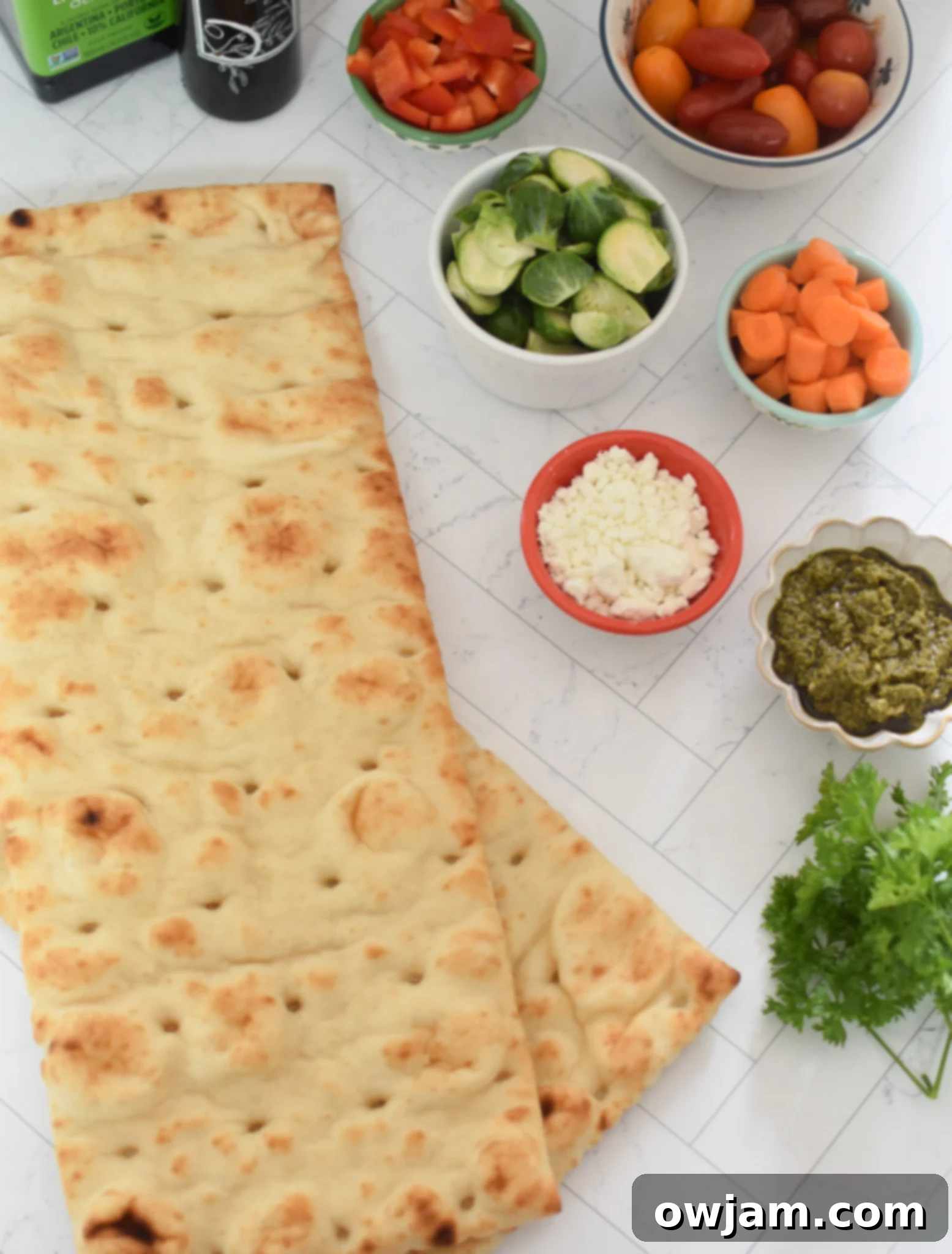 Roasted Vegetable Goat Cheese Flatbread Pizza Recipe ingredients laid out on a table.