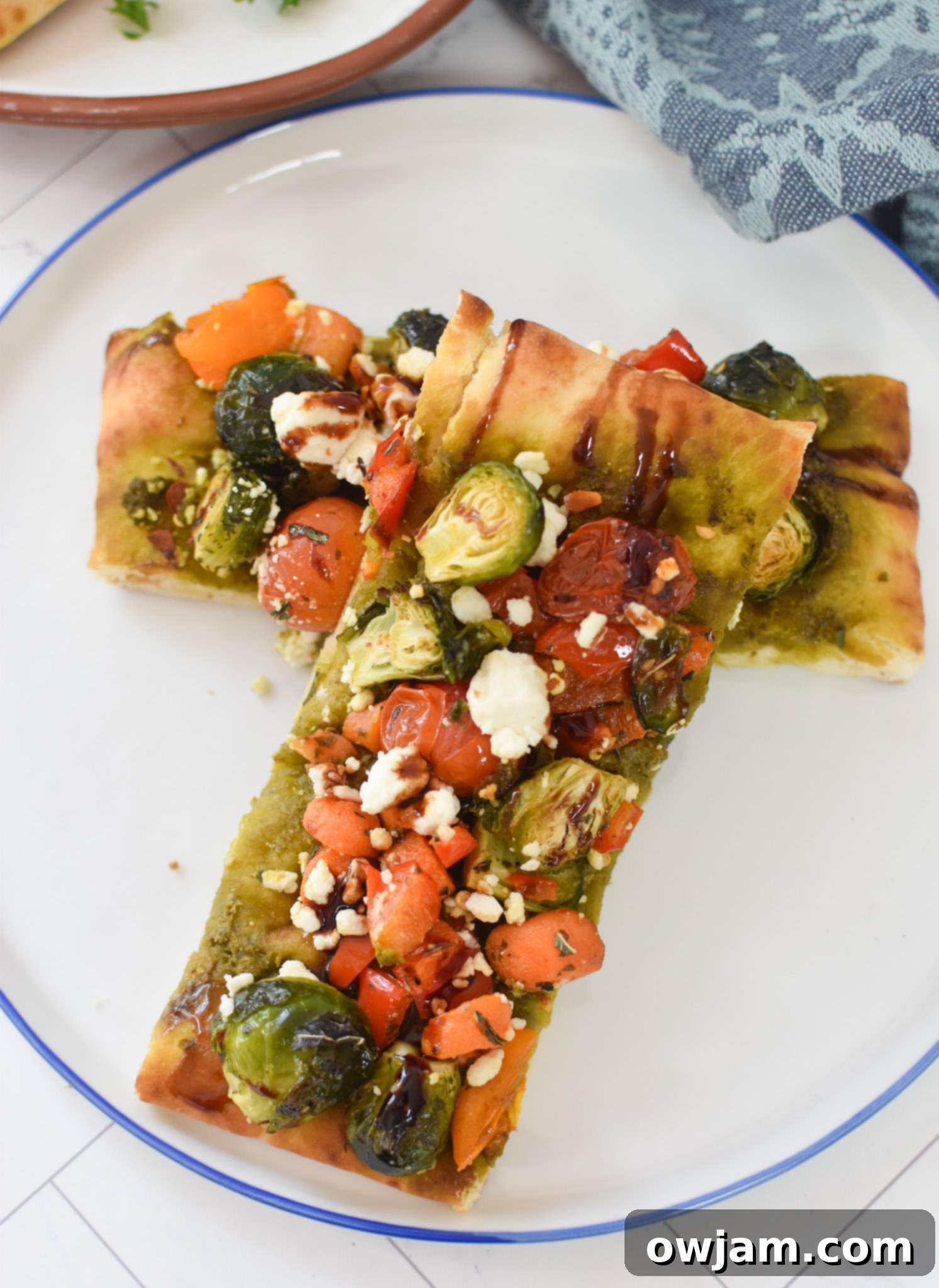 Roasted Vegetable Goat Cheese Flatbread Pizza Recipe on a white plate, ready to serve.