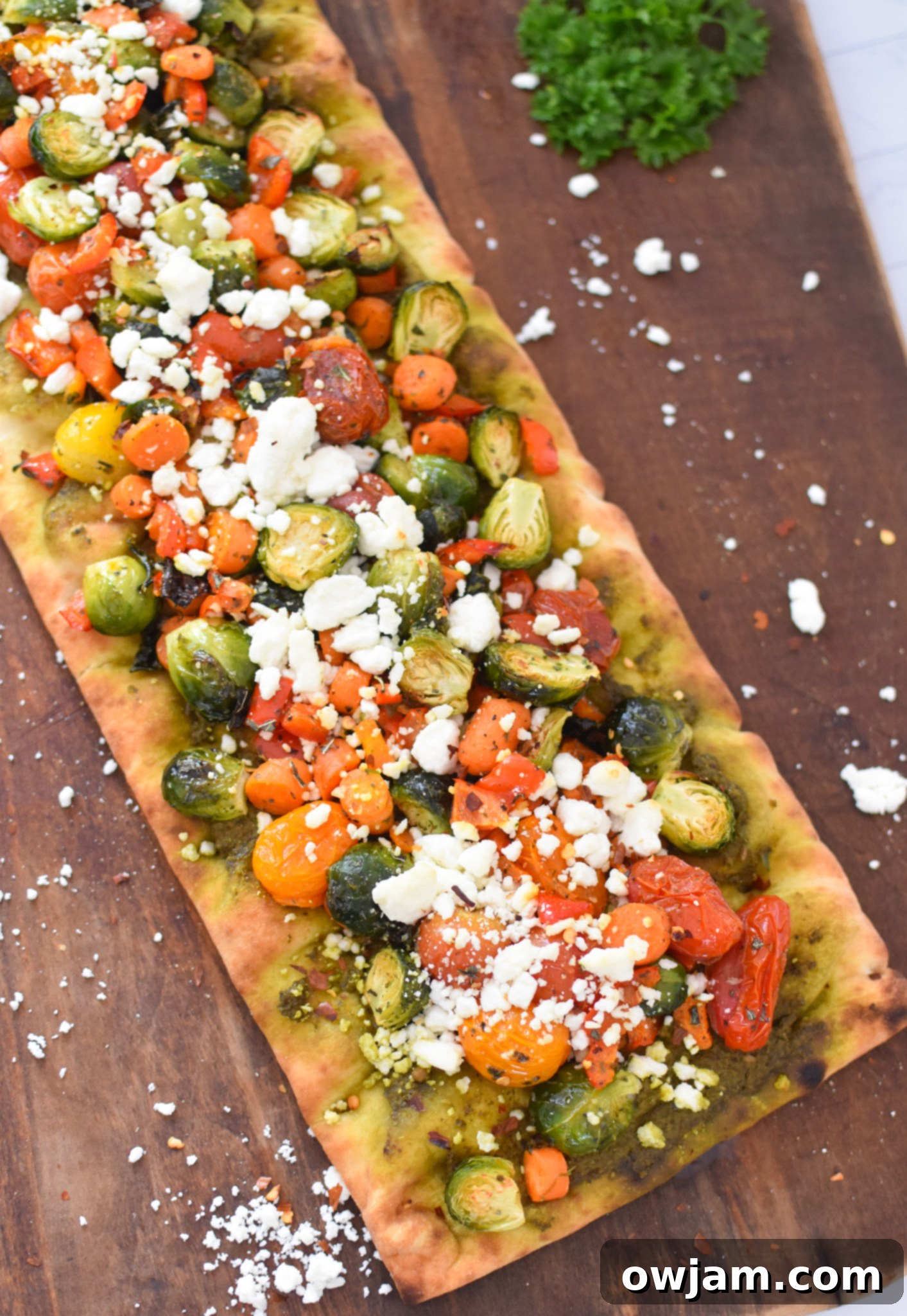 Roasted Vegetable Goat Cheese Flatbread Pizza Recipe with goat cheese and roasted vegetables on top.