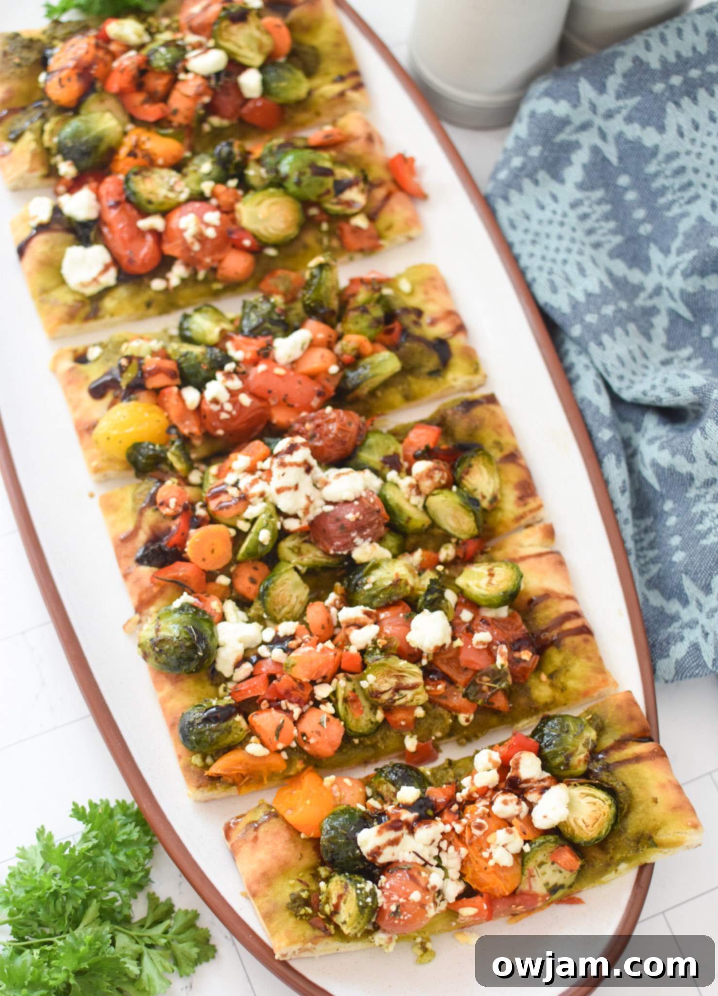 Roasted Vegetable Goat Cheese Flatbread Pizza Recipe sliced on a cutting board, ready to serve.