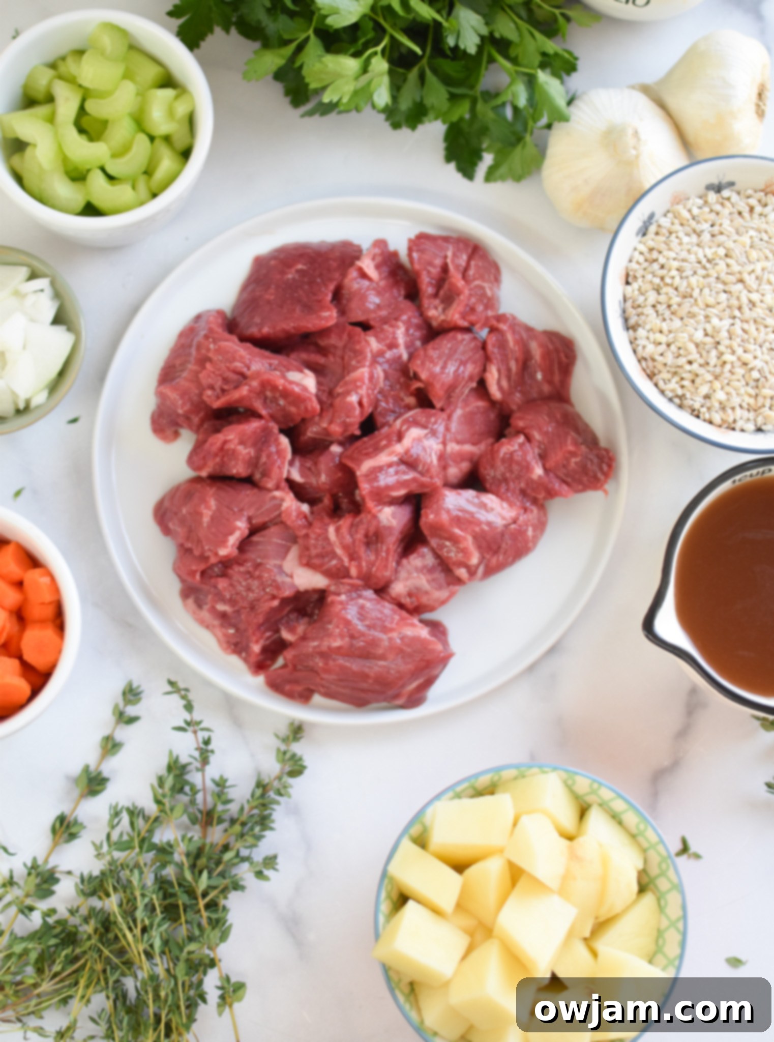 Hearty Slow Cooker Beef Barley Soup 4 Selection of fresh ingredients for Slow Cooker Beef Barley Soup including beef, potatoes, carrots, celery, onion, and spices.