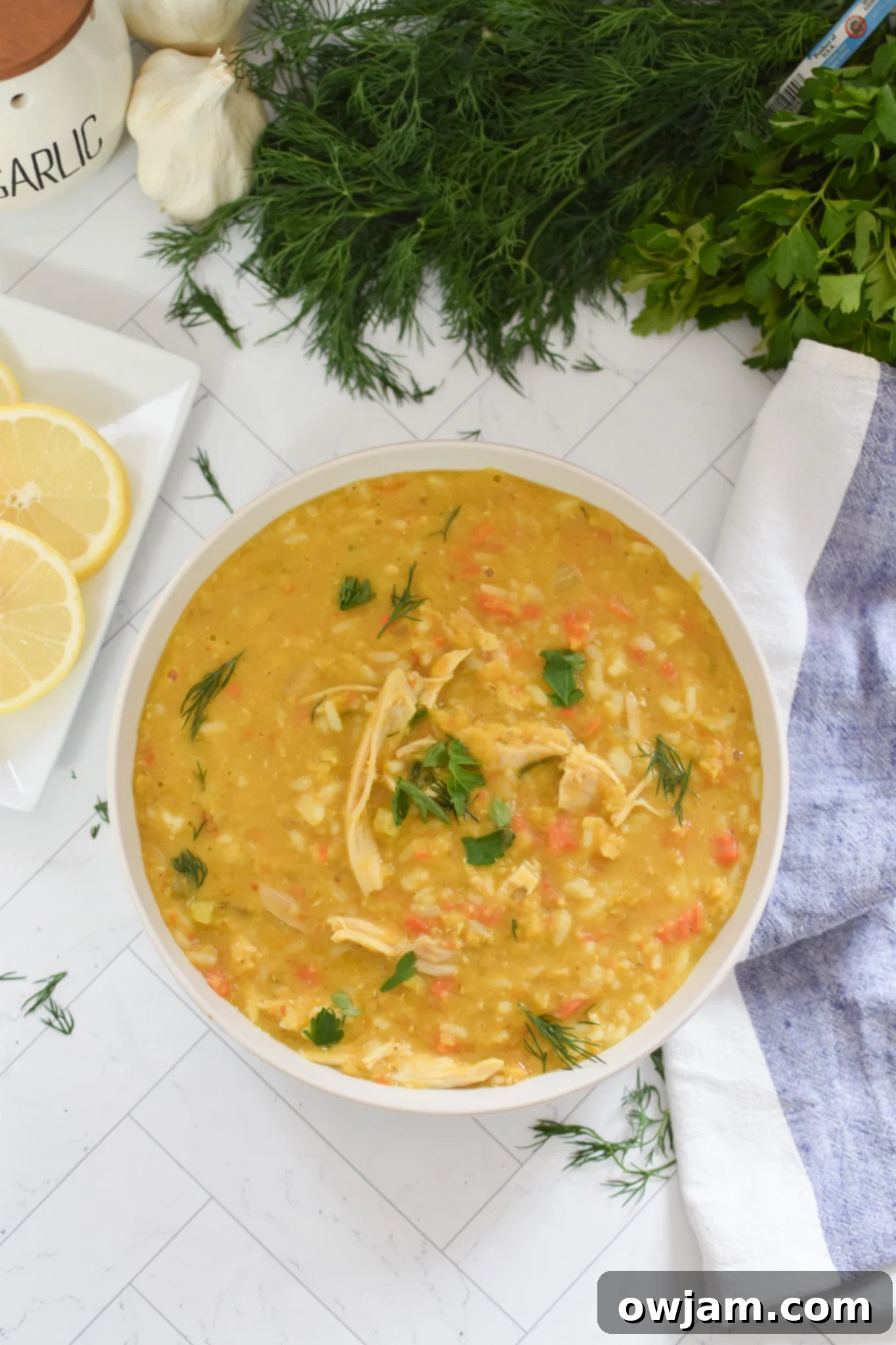 A bowl of Chicken Lentil Soup topped with fresh herbs, ready to be eaten.