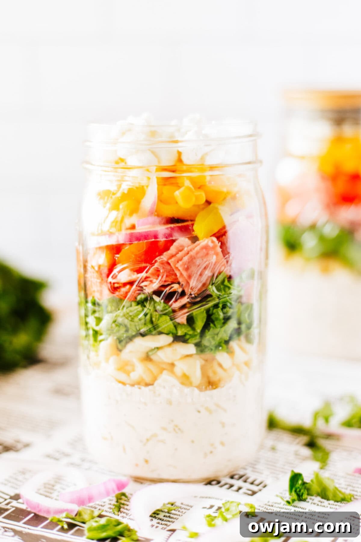 Portable Italian Pasta Salad Jar 3 Italian Pasta Mason Jar Salad, with colorful layers visible through the glass jar.