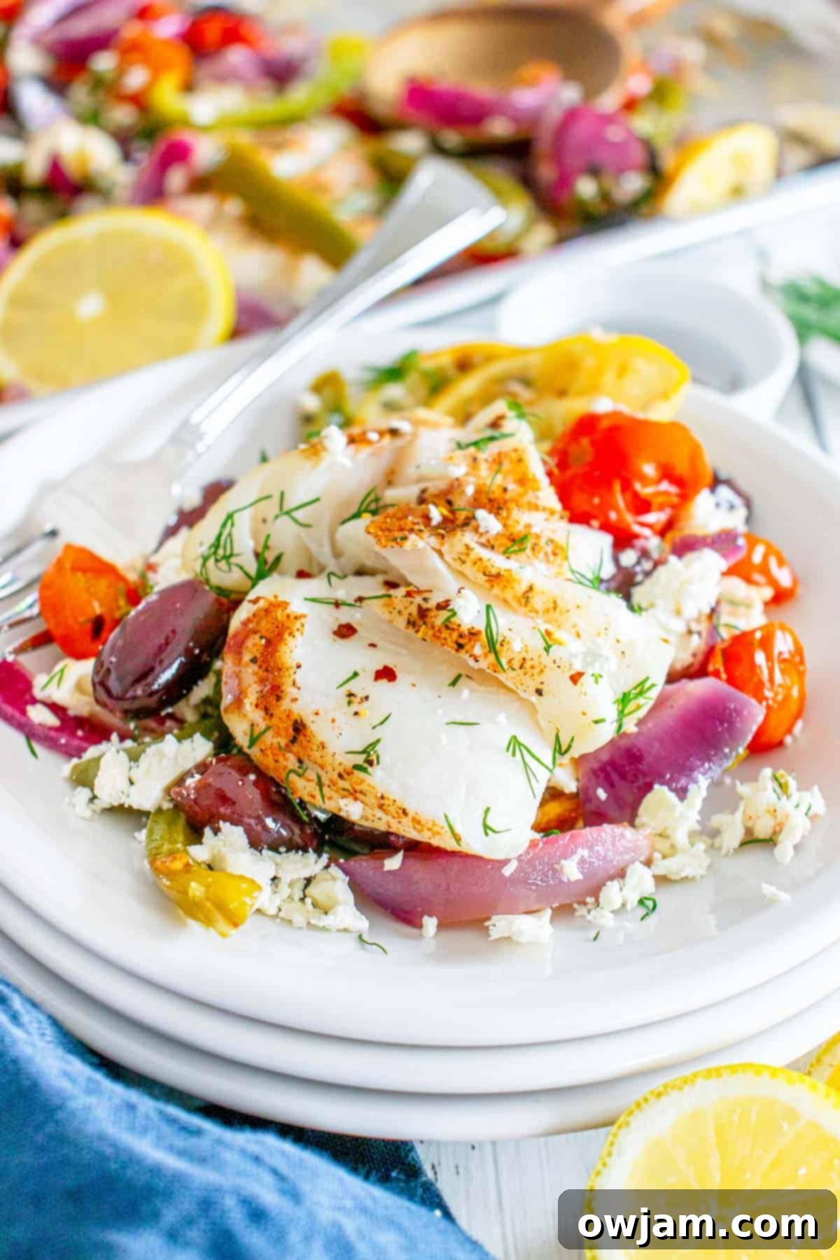 Sheet Pan Mediterranean Cod on a white bowl with fork