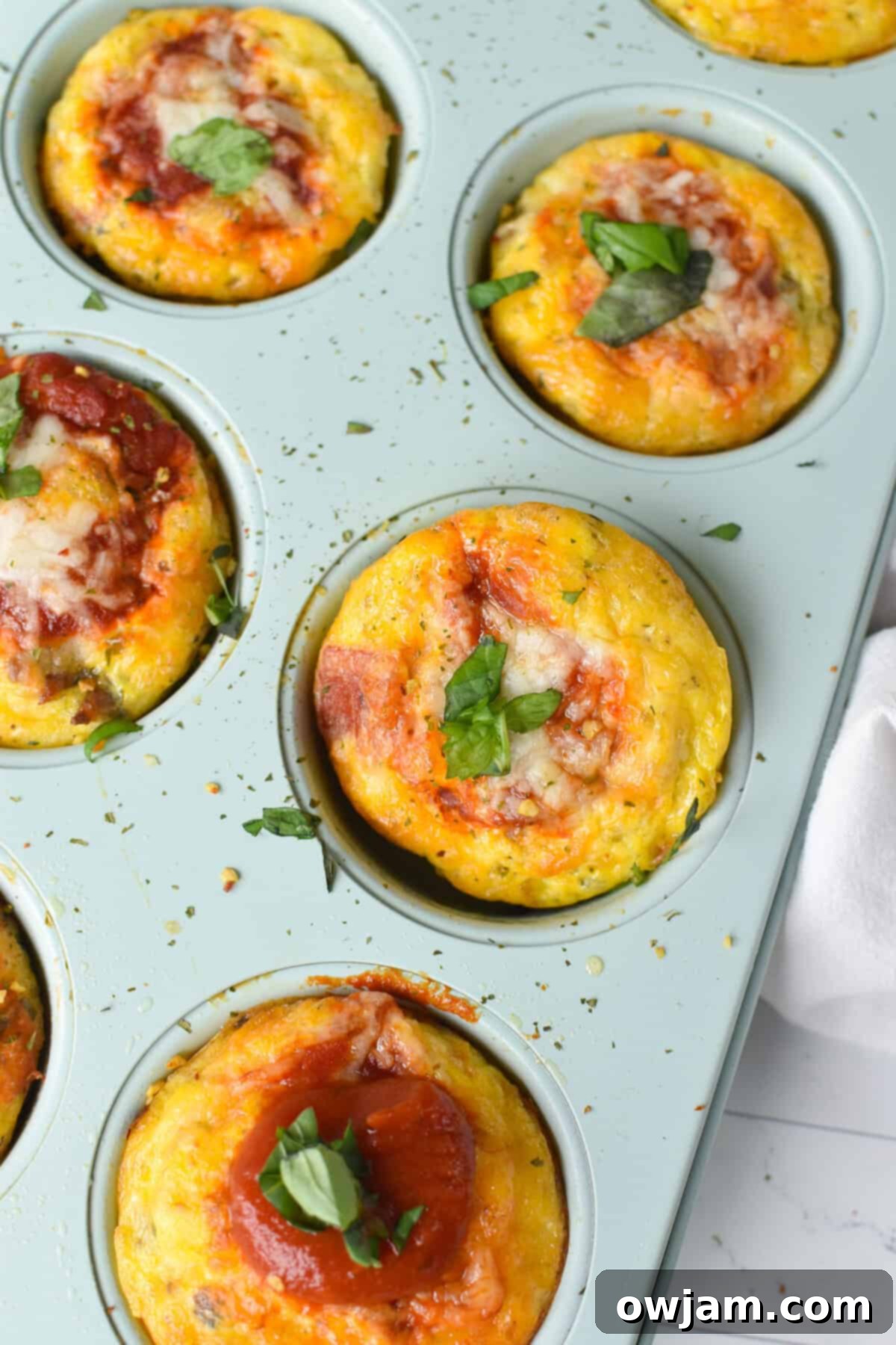 Cheesy Pizza Egg Bites 2 Pizza Egg Muffins in a muffin tin, ready to be enjoyed