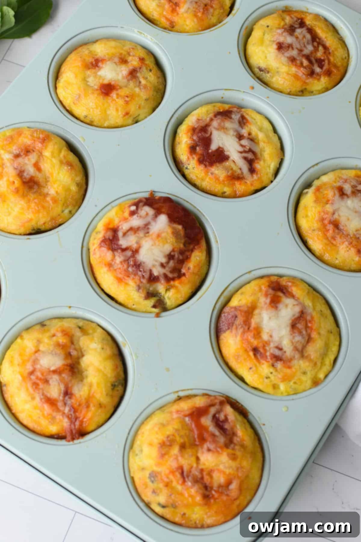 Cheesy Pizza Egg Bites 10 Pizza Egg Muffins in a bright blue muffin tin