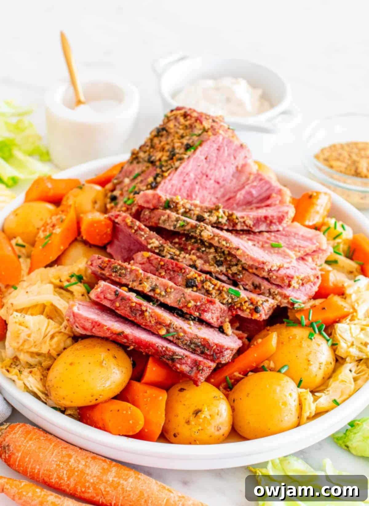Homestyle Baked Corned Beef & Cabbage 2 Baked Corned Beef and Cabbage served on a white plate with potatoes and carrots