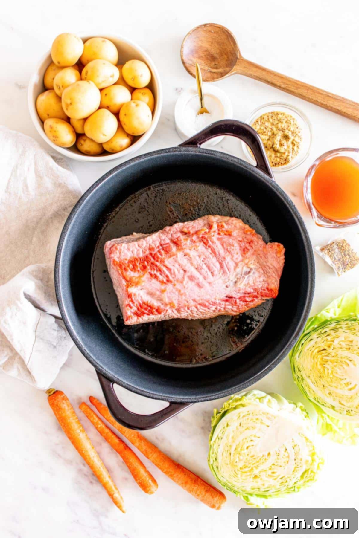 Homestyle Baked Corned Beef & Cabbage 6 Raw Corned Beef Brisket being placed into a Dutch Oven with broth and vegetables
