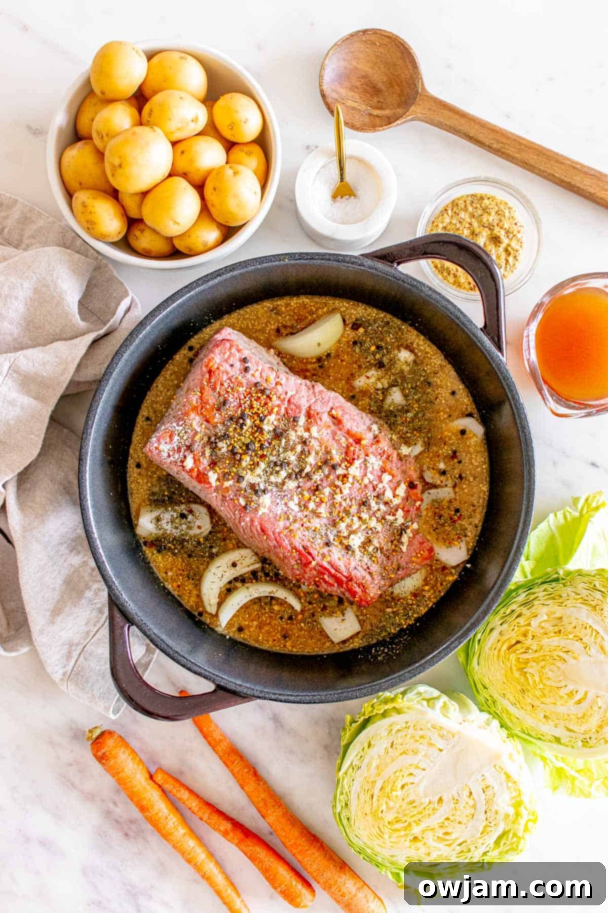 Homestyle Baked Corned Beef & Cabbage 7 Corned Beef and Cabbage simmering in broth within a Dutch oven