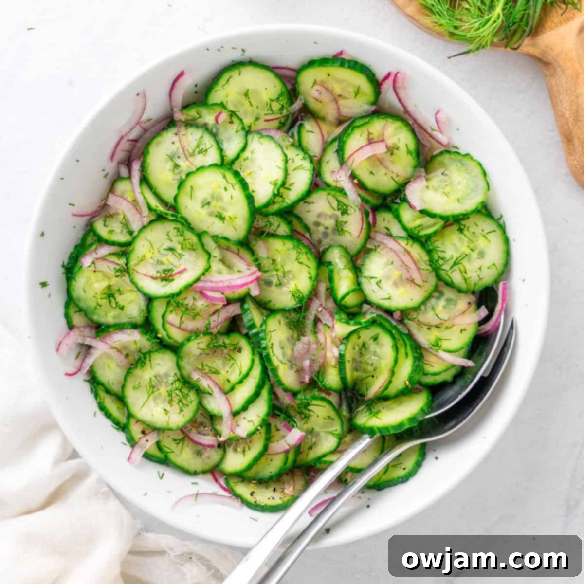 Cucumber Onion Salad presented beautifully with a napkin and spoons, ready for serving