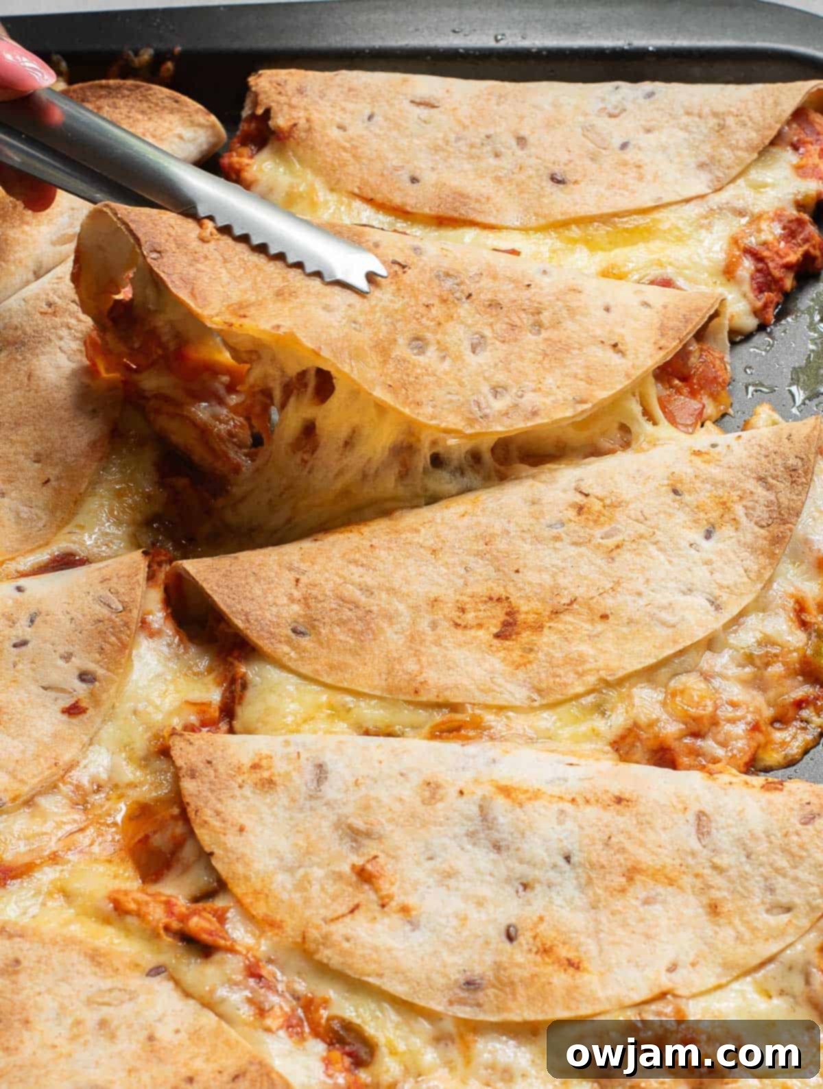 Crispy Baked Chicken Tacos being served with tongs