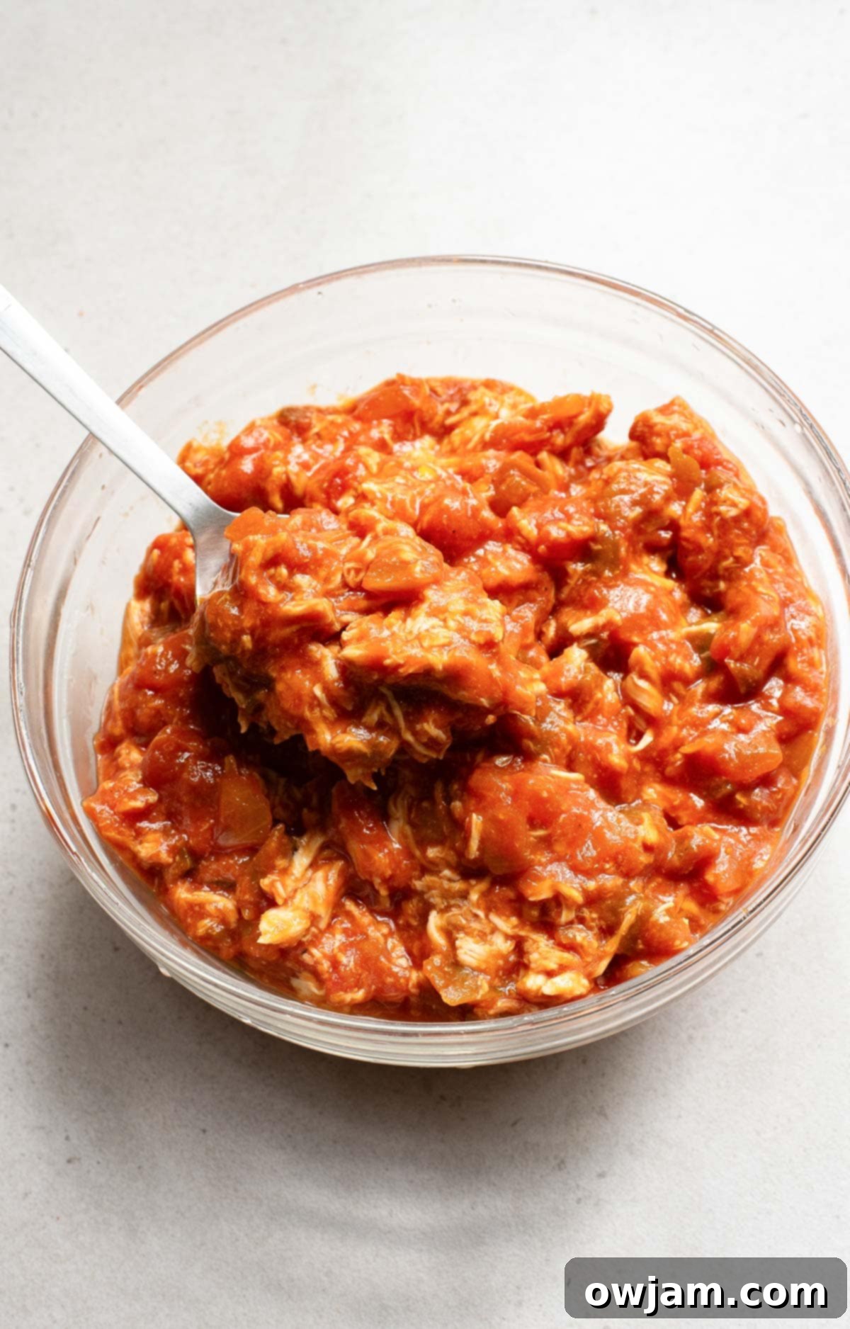Shredded chicken and salsa mixture in a bowl, ready for taco filling