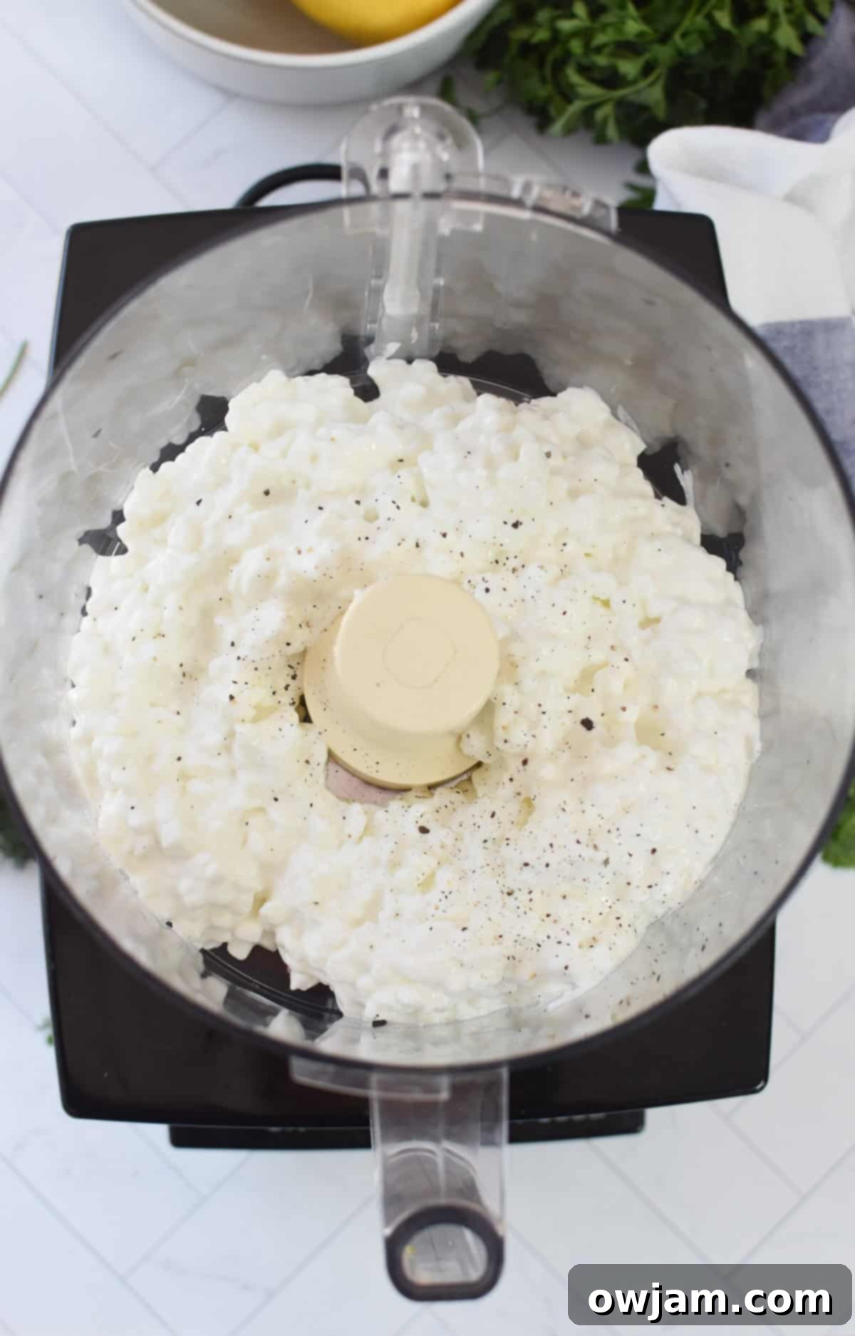Velvety Cottage Cheese 6 Cottage cheese and black pepper being added to a blender for whipping