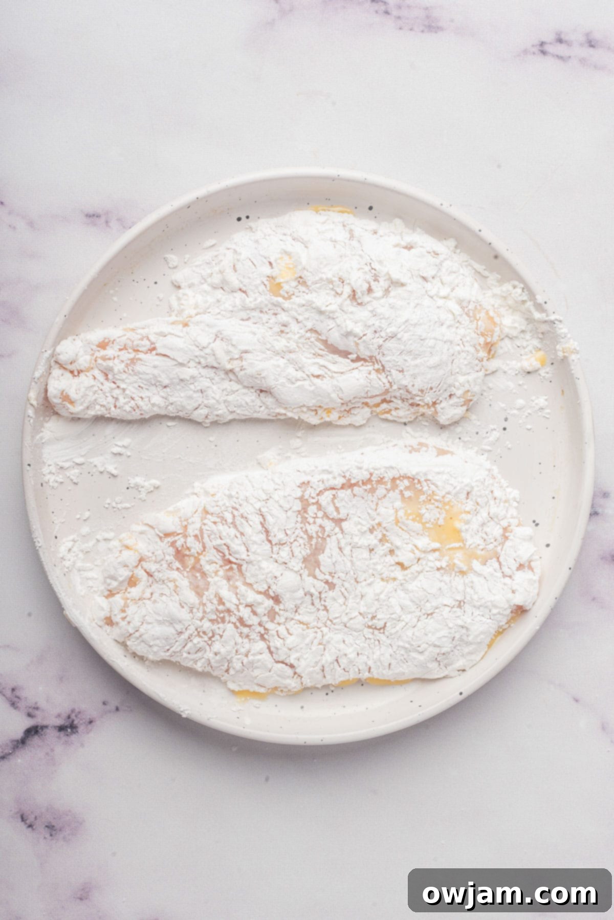 Air Fryer Chicken Breast being dredged in cornstarch