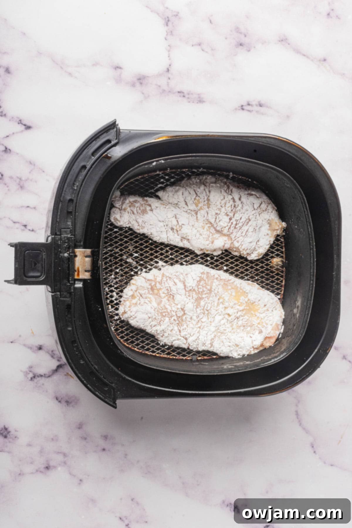 Air Fryer Chicken Breast cooking in an air fryer basket